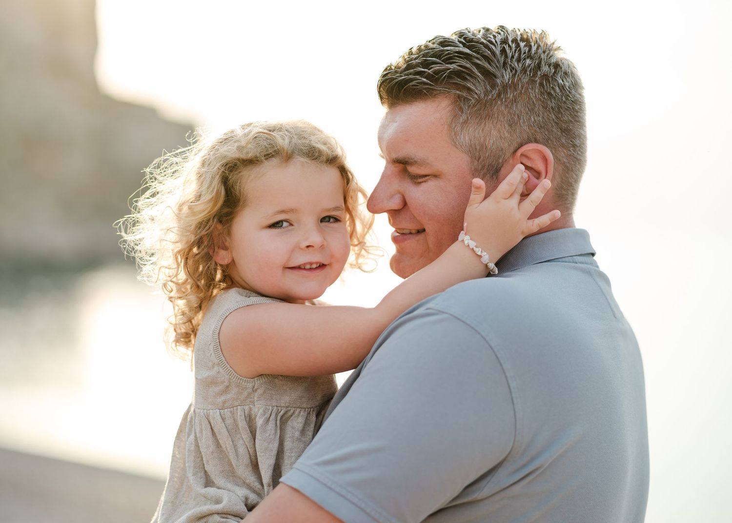 Sweet embrace between parent and child with sunset light streaming behind them. Fotograf Rhodos
