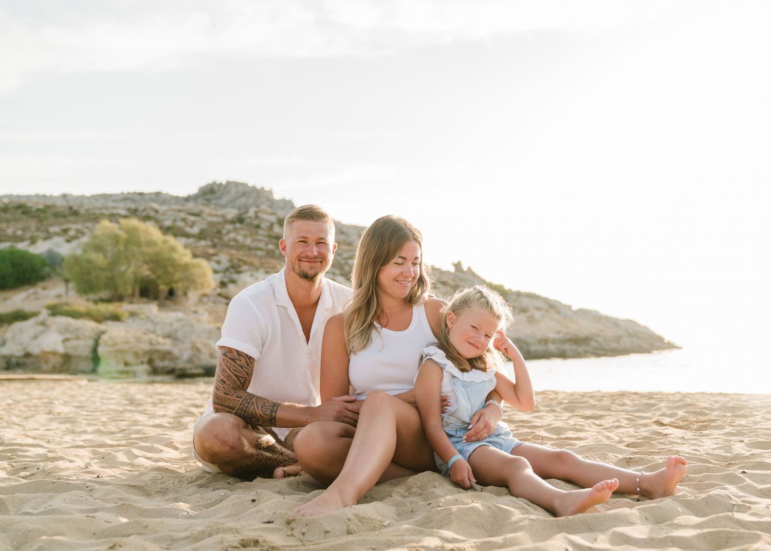 Family beach photography session with relaxed poses on sandy shore at sunset. Fotograf Rhodos