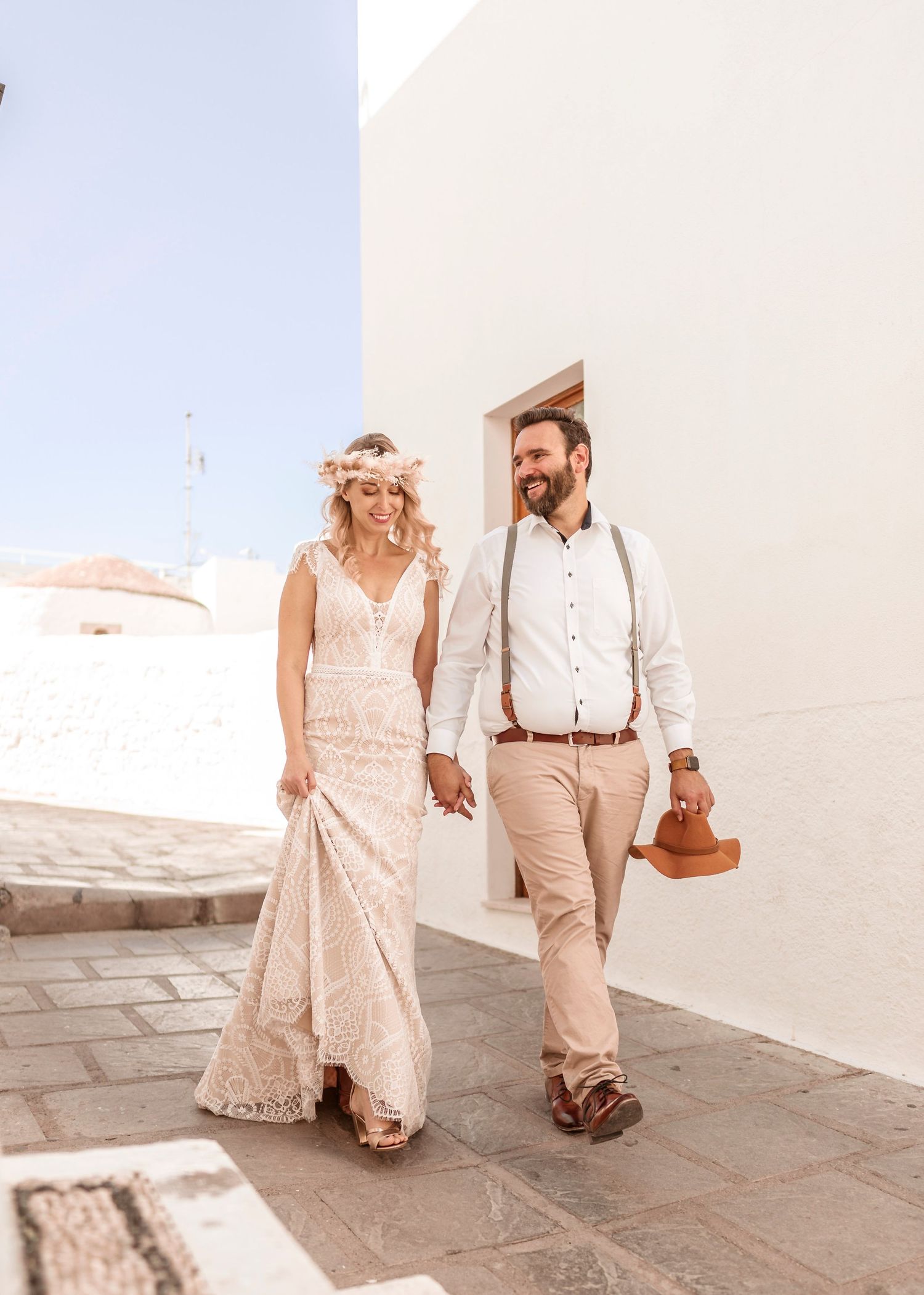 A couple in vintage-inspired attire strolls along a white stone pathway.hochzeitsfotograf Griechenland - Hochzeitsfotograf Rhodos Tina Luciu