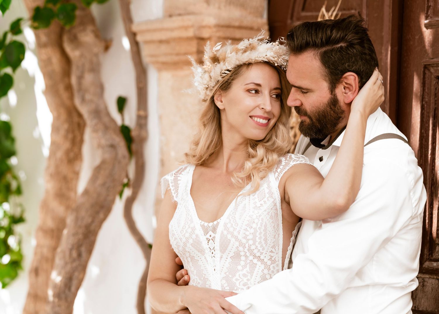 A romantic couple dressed in white sits intimately on stone steps for an engagement phothochzeitsfotograf Griechenland - Hochzeitsfotoshoot.