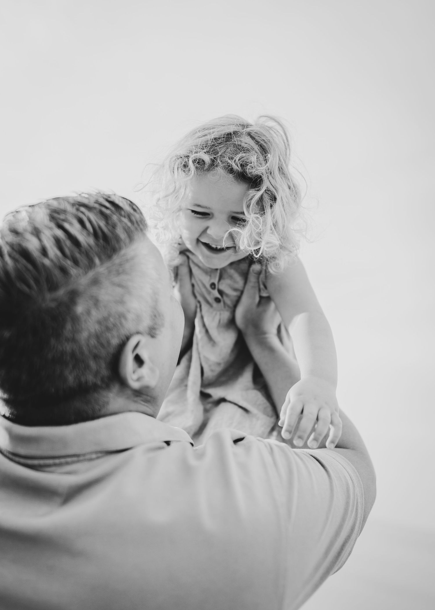 Black and white portrait capturing a joyful moment between parent and child. Fotograf Rhodos