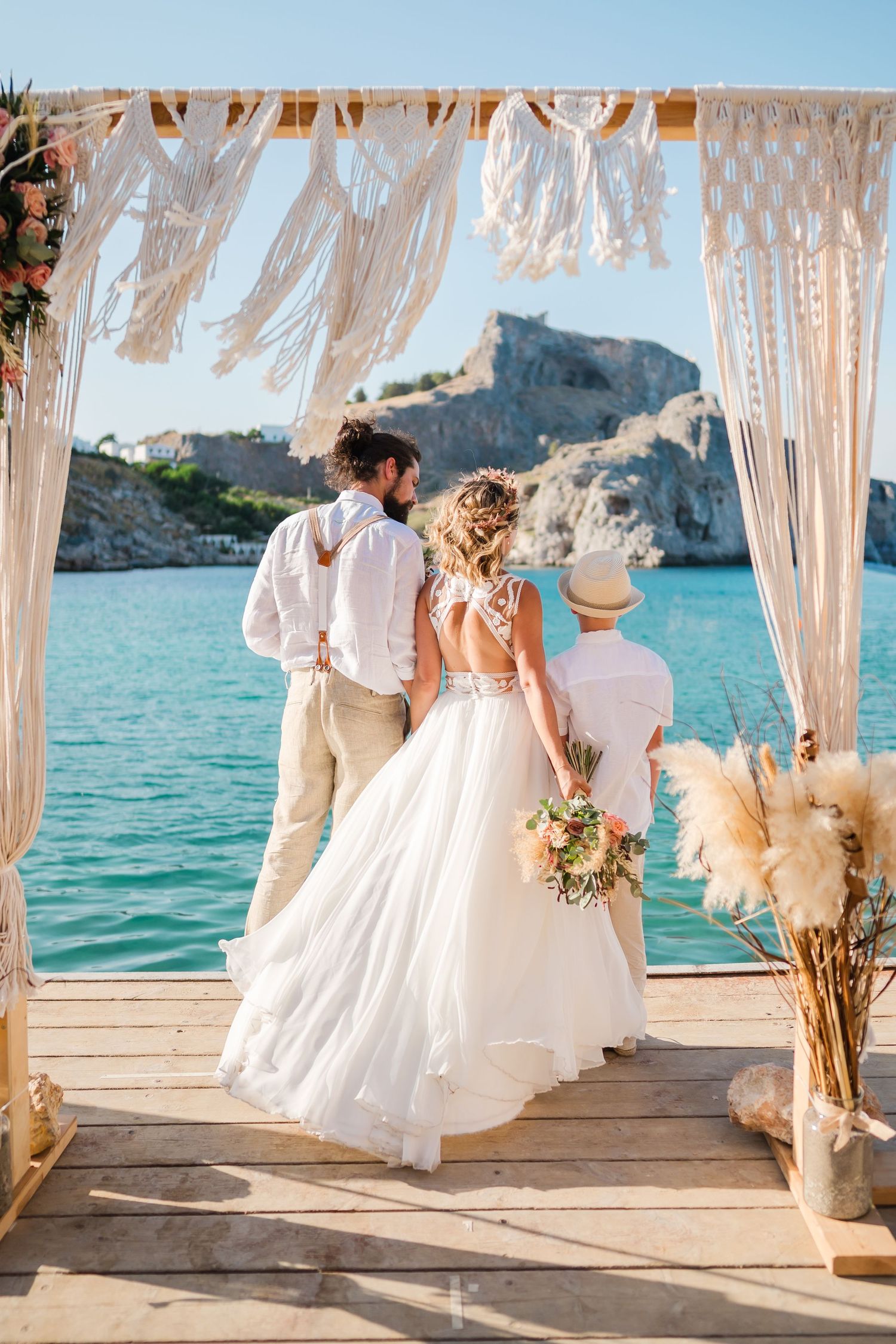 Couple having their first dance on a decorated oceanfront platform with flowing white curtains.Strandhochzeit Rhodos - Hochzeitsfotograf Rho