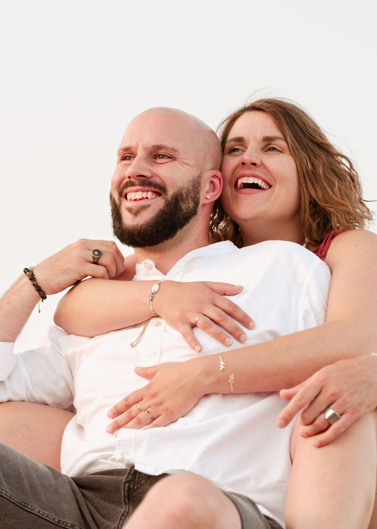 Candid moments of couple laughing and embracing in studio setting.