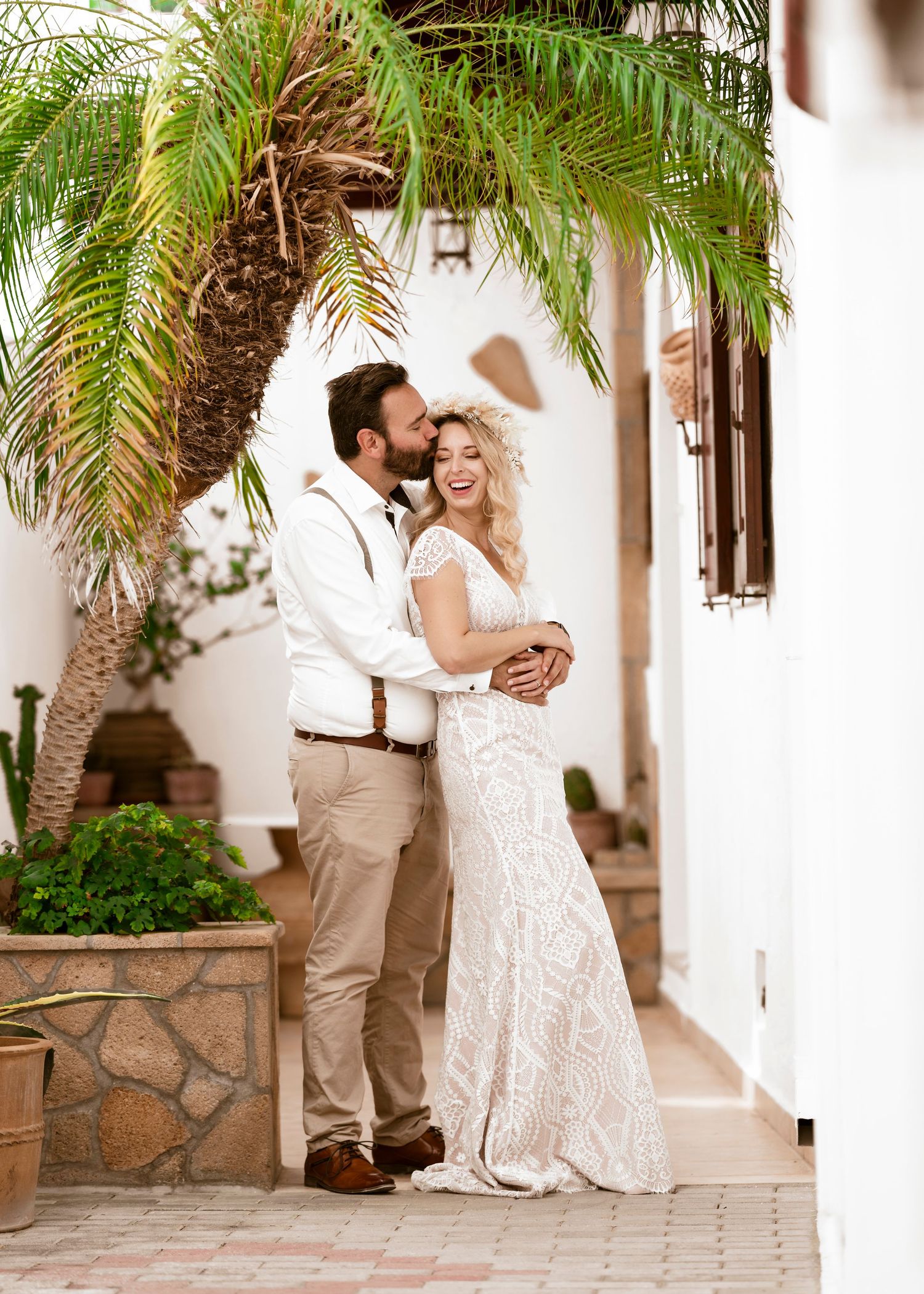 A joyful wedding couple shares tender moments in a tropical courtyard setting.hochzeitsfotograf Griechenland - Hochzeitsfotograf Rhodos Tina