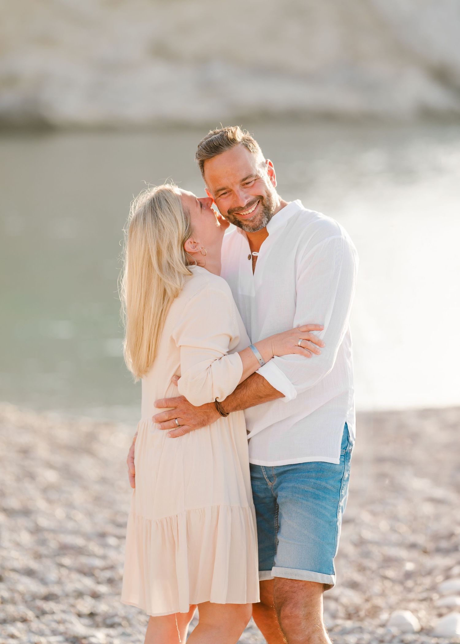 A romantic moment shared between a couple on a rocky beach at sunset. Fotograf Rhodos
