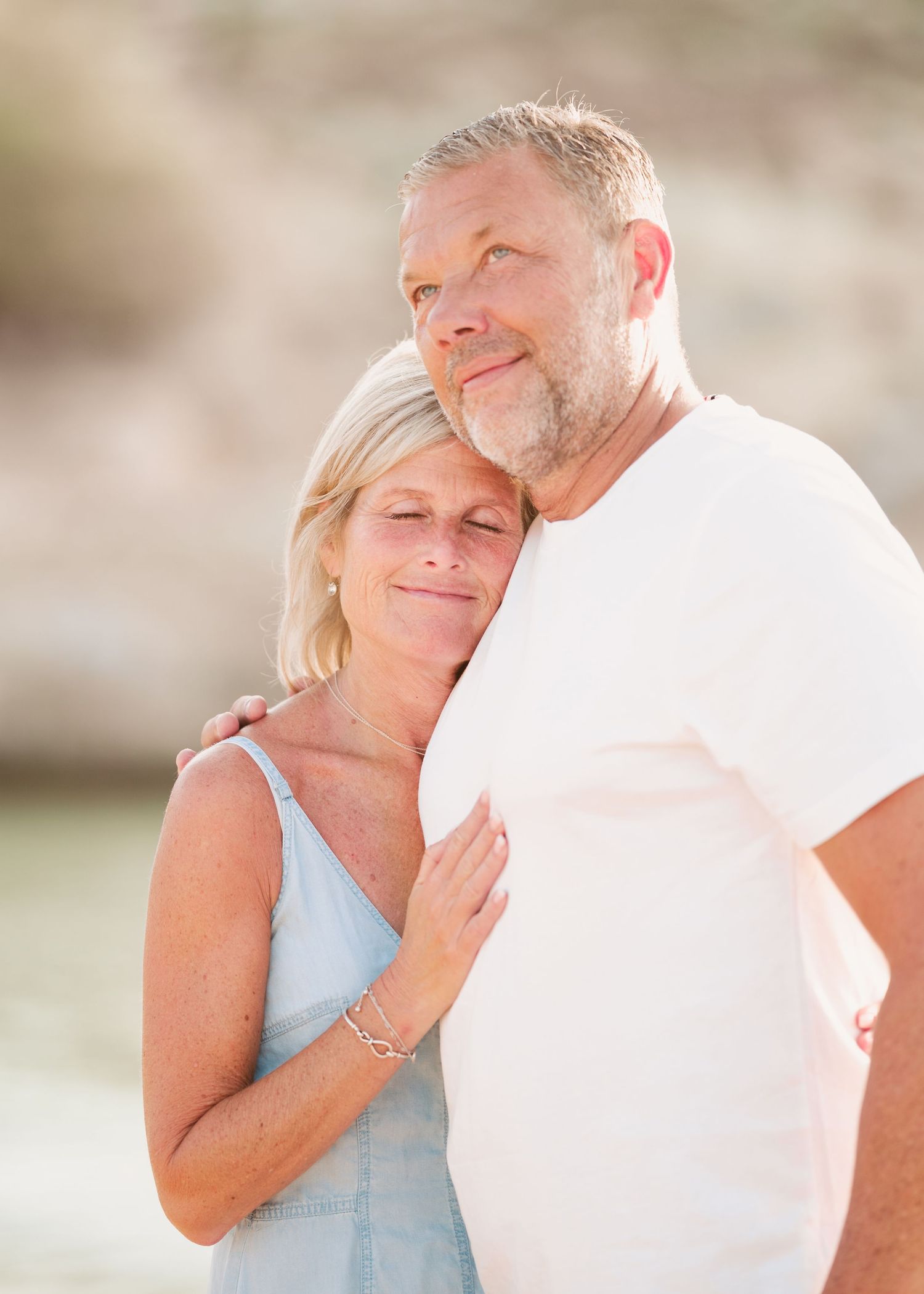 A couple shares intimate moments at sunset on the beach with golden light filtering through. Fotograf Rhodos