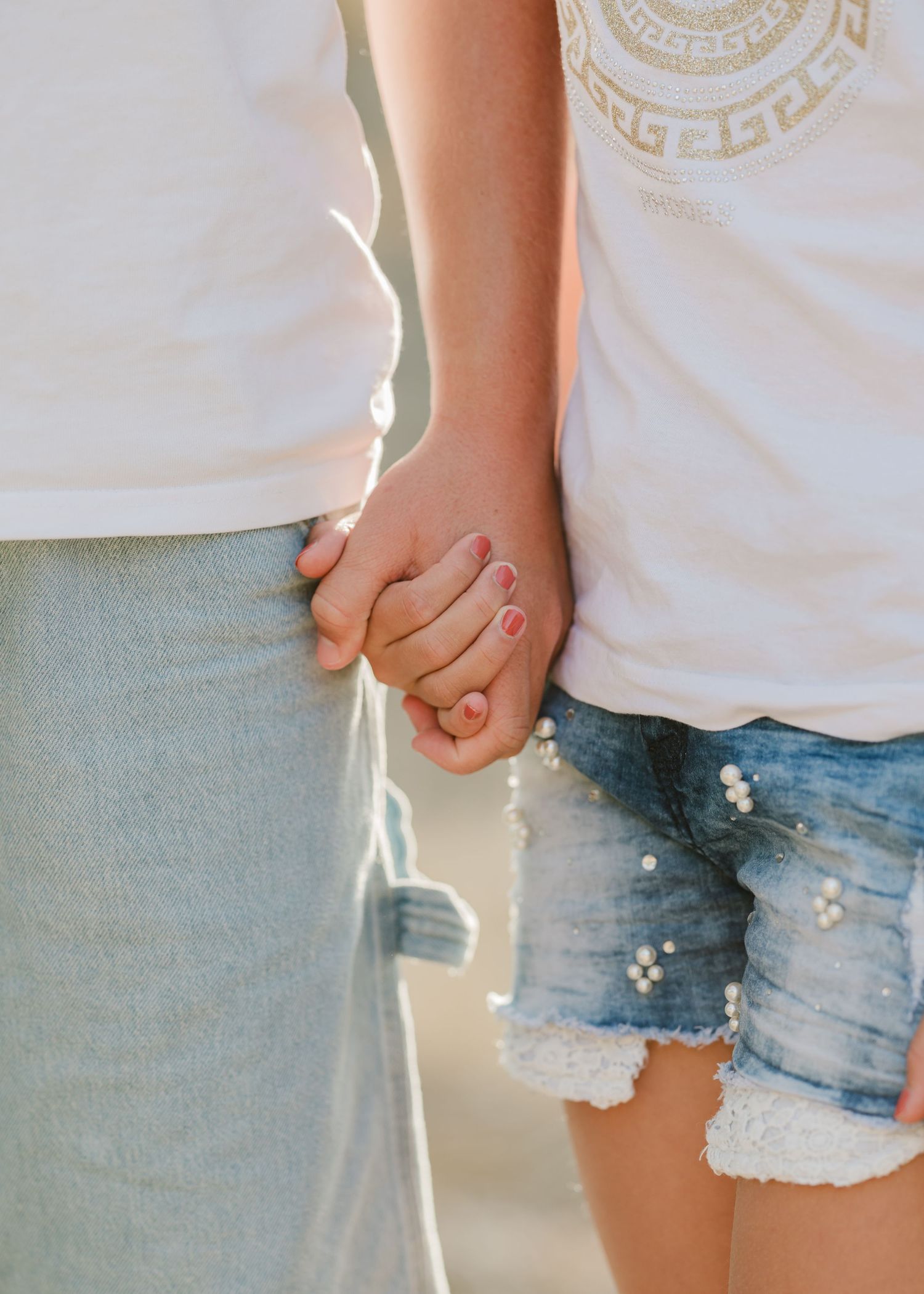 Close-up of hands holding together while wearing denim shorts. Fotograf Rhodos