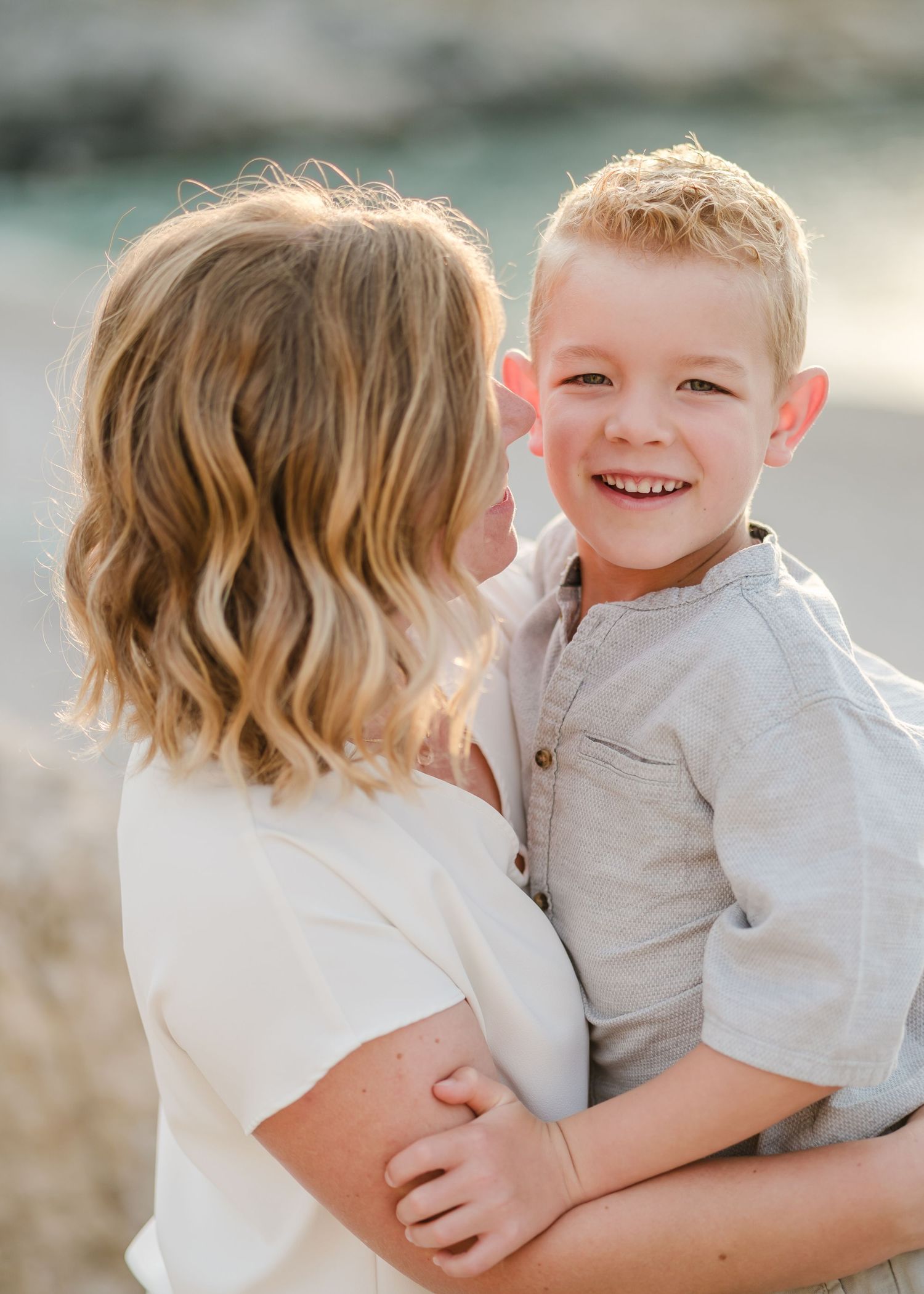 Candid portrait of parent and child sharing a loving moment by the ocean. Fotograf Rhodos