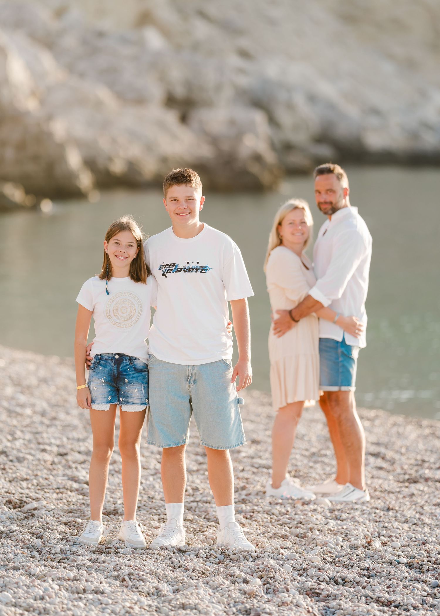 Group portrait on a rocky beach with calm waters and limestone cliffs in the background. Fotograf Rhodos
