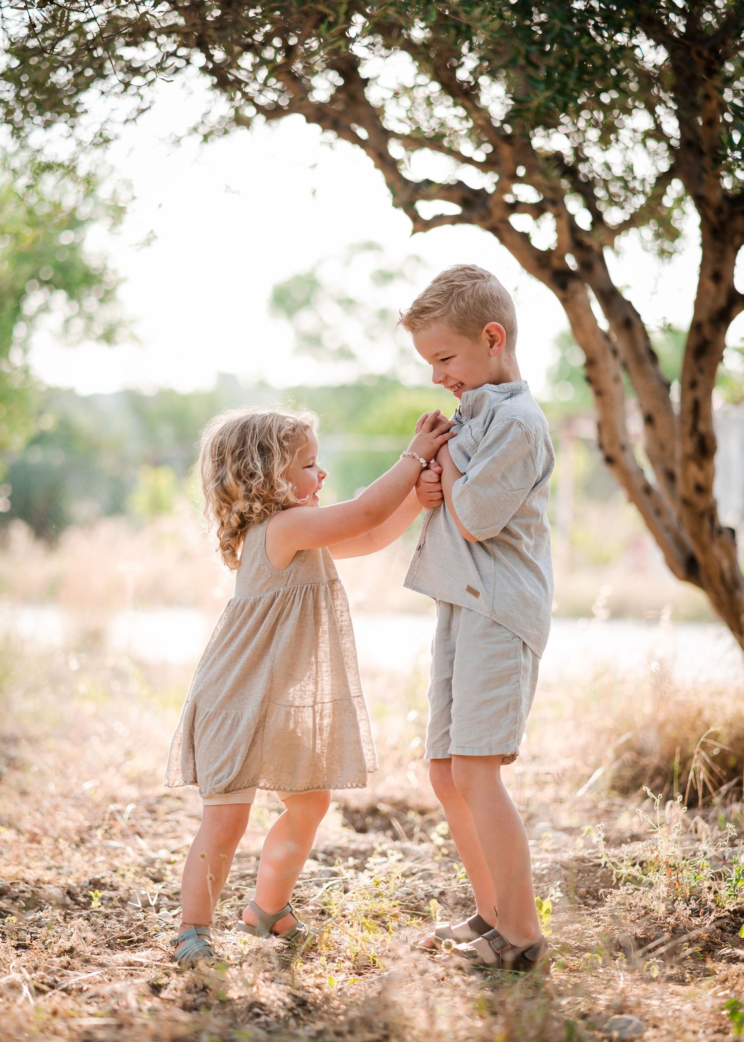 Children playing and laughing together under trees on a natural outdoor setting. Fotograf Rhodos