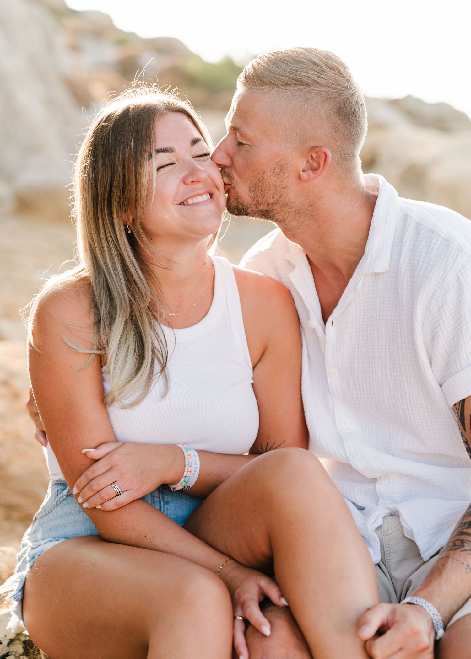 Intimate couple moment captured against rocky landscape during sunset photoshoot. Fotograf Rhodos