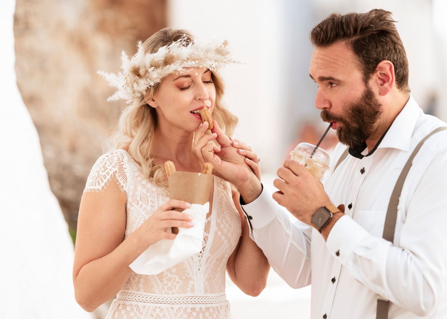 Newlywed couple shares intimate moments while tasting treats at their wedding celebration.hochzeitsfotograf Griechenland - Hochzeitsfotograf