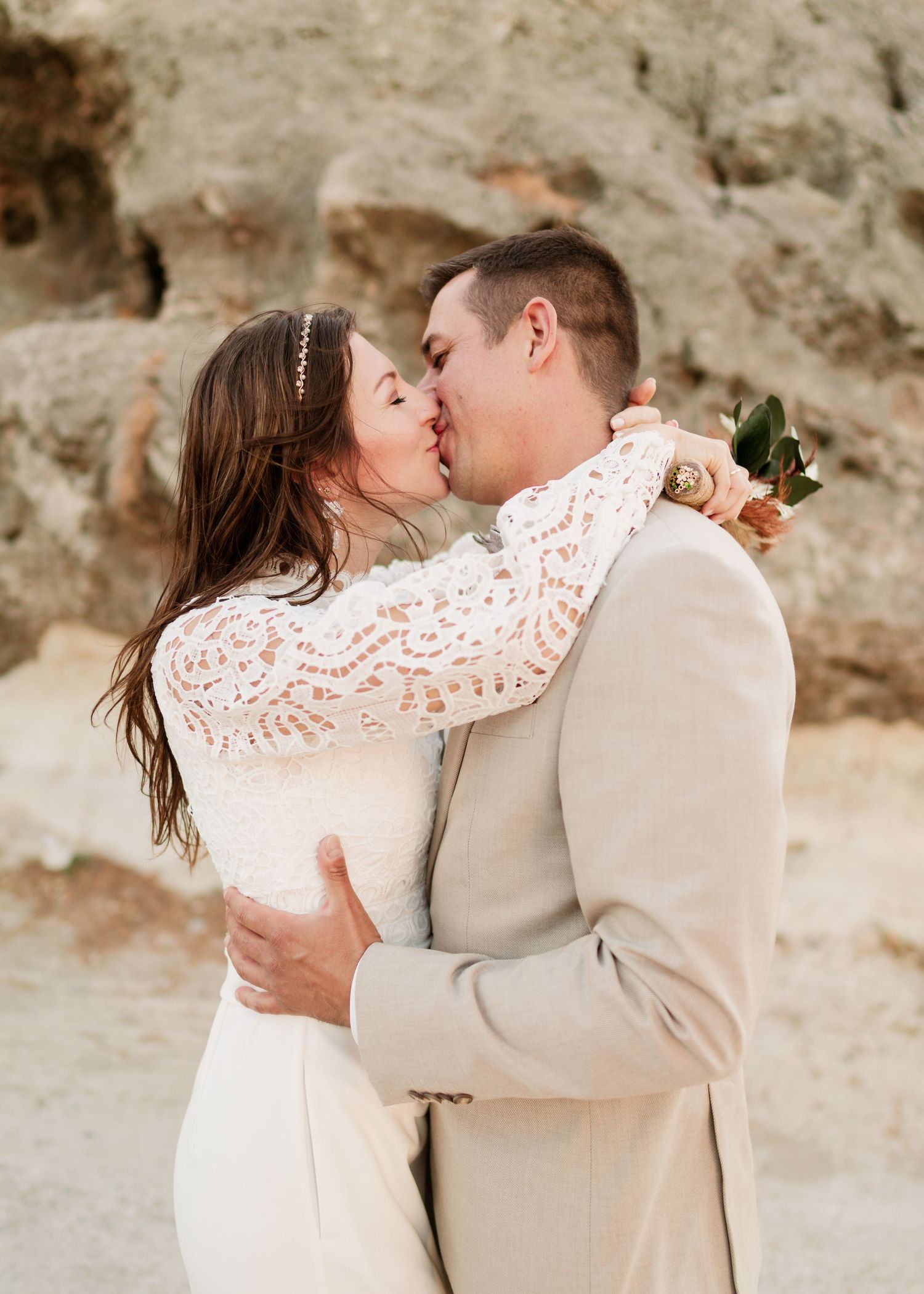 Intimer Hochzeitsmoment in Wüstenkulisse mit Paaren in weiß-beiger Kleidung festgehalten. Strandhochzeit Rhodos - Hochzeitsfotograf Rhodos T