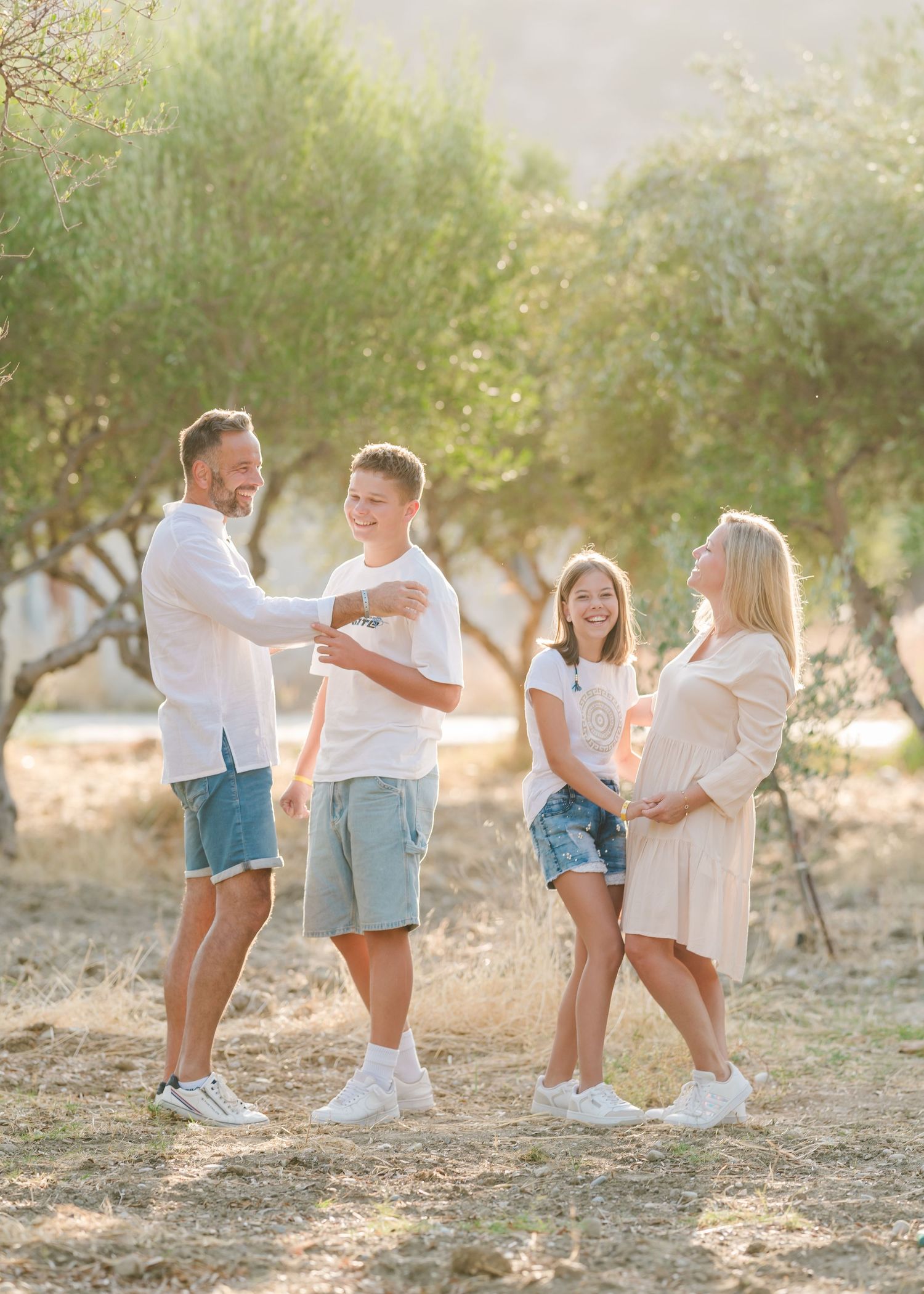 Candid moments of family interaction in an olive grove with soft afternoon lighting. Fotograf Rhodos
