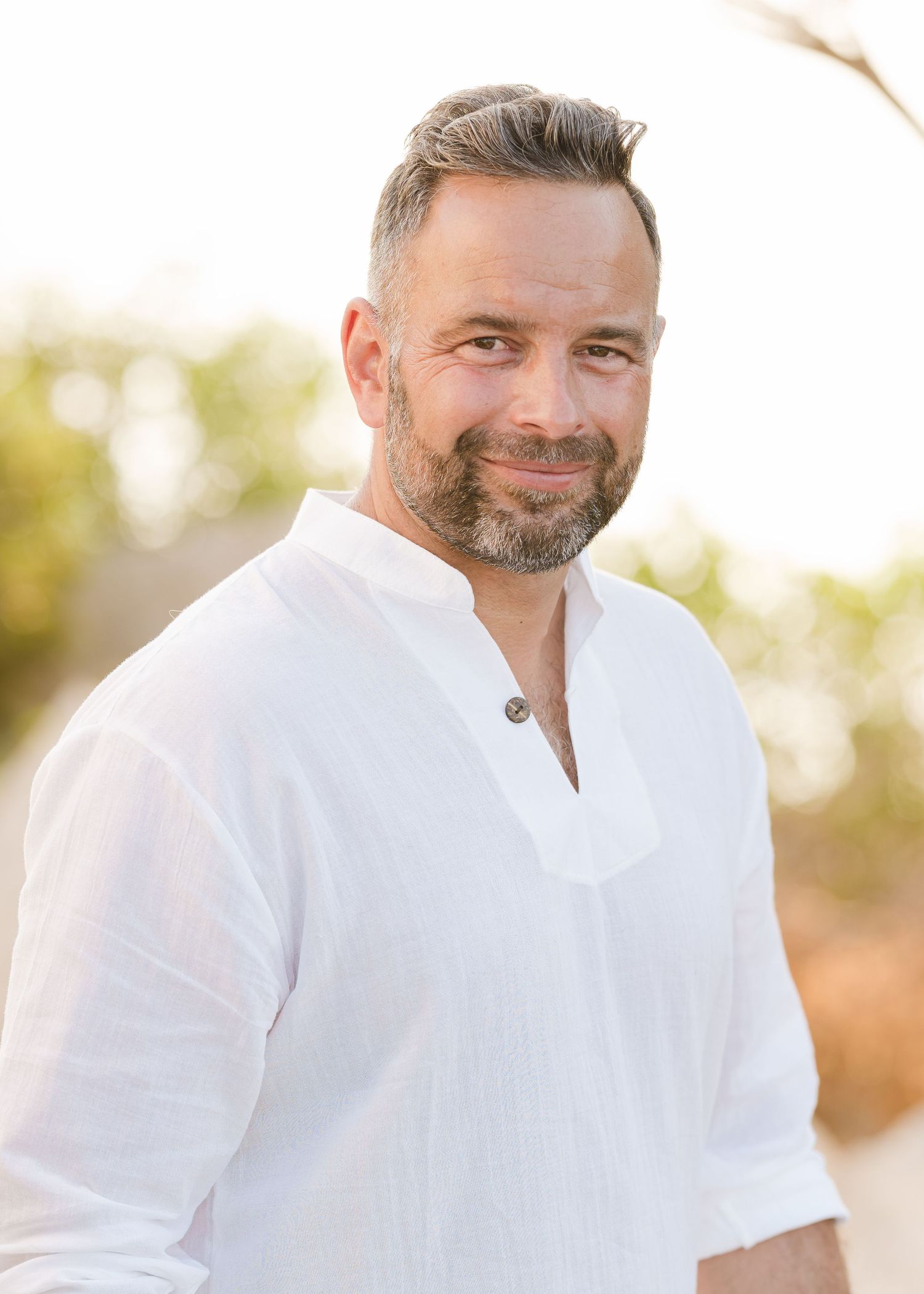 Person in white button-down shirt smiling during outdoor portrait session. Fotograf Rhodos
