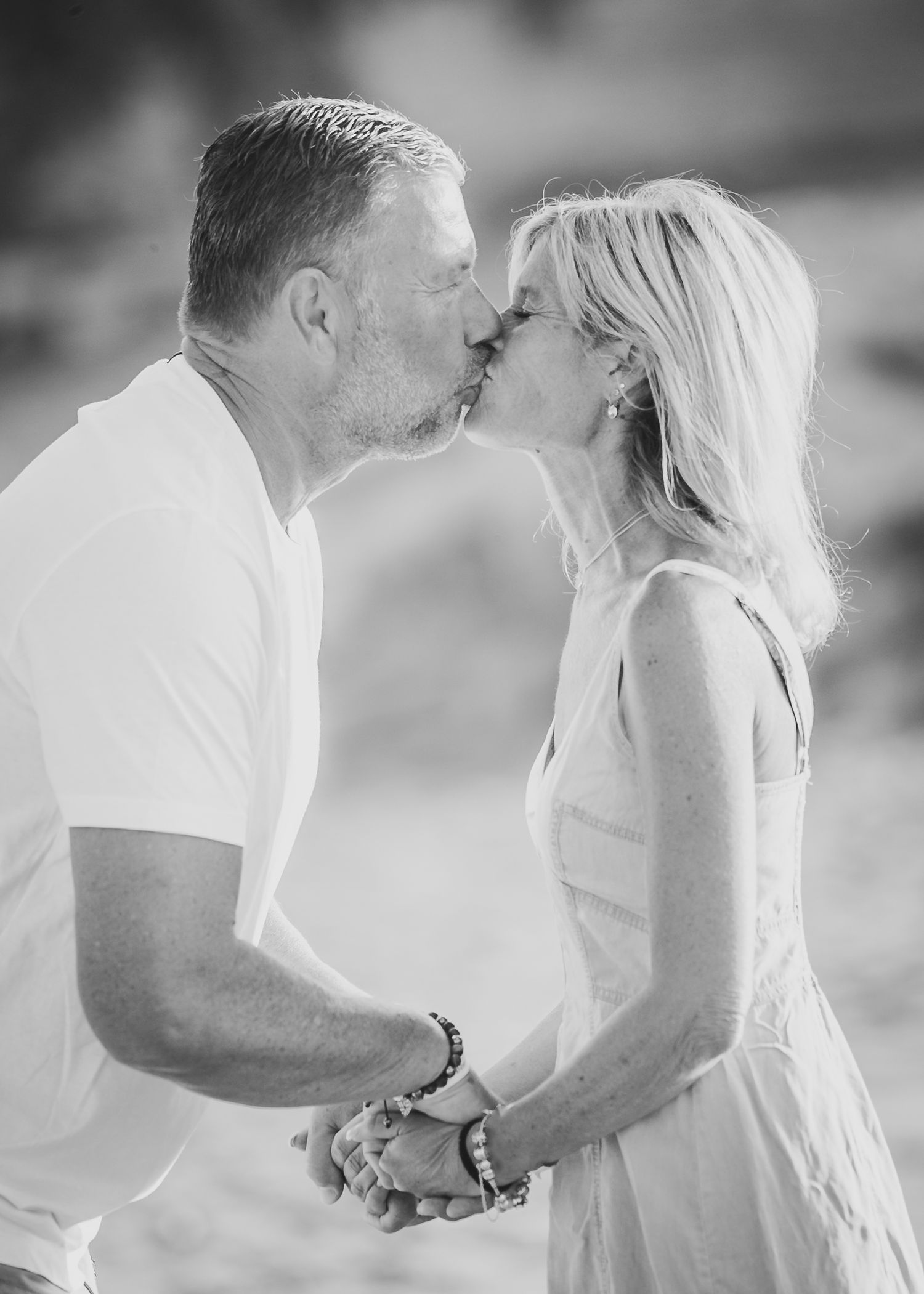 Intimate black and white portrait of couple sharing romantic moment on beach. Fotograf Rhodos