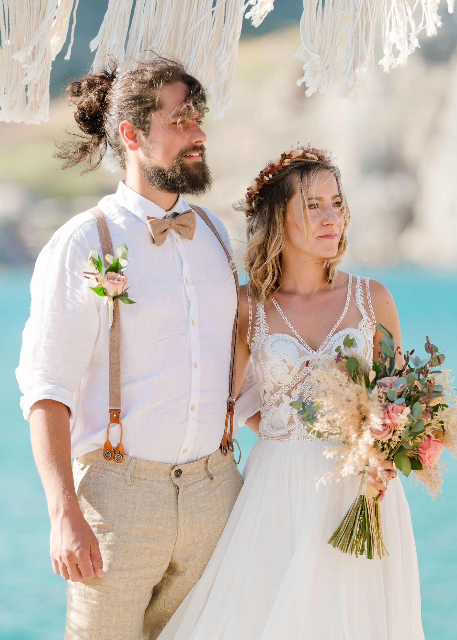 Couple in beach wedding attire standing together by turquoise water.Strandhochzeit Rhodos - Hochzeitsfotograf Rhodos Tina Lucius