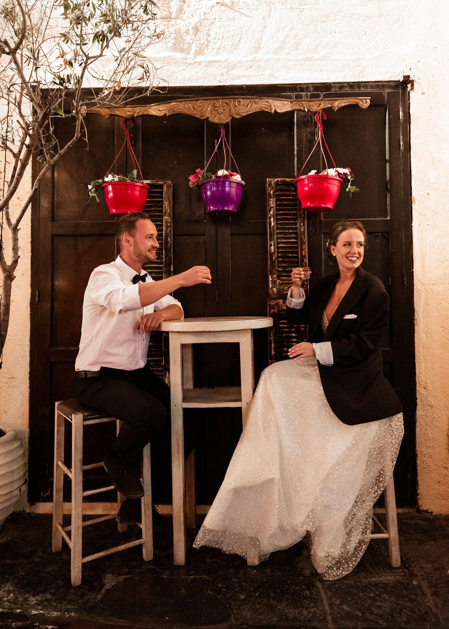 Wedding couple dancing and celebrating in a rustic venue with hanging red and purple Shooting kallithea - Hochzeitsfotograf Rhodos lanterns.
