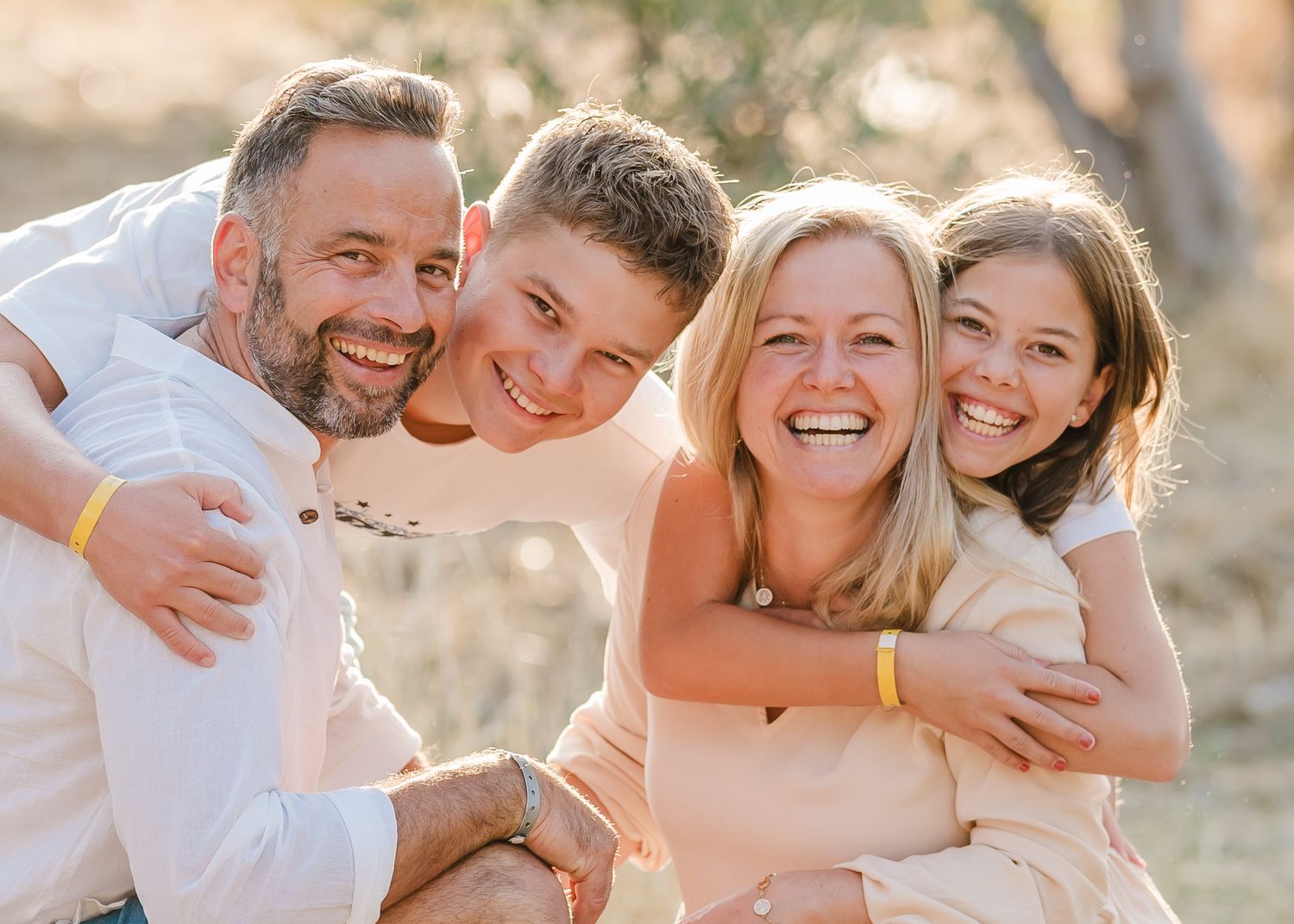 Candid portrait of embracing group laughing together in warm sunlight. Fotograf Rhodos