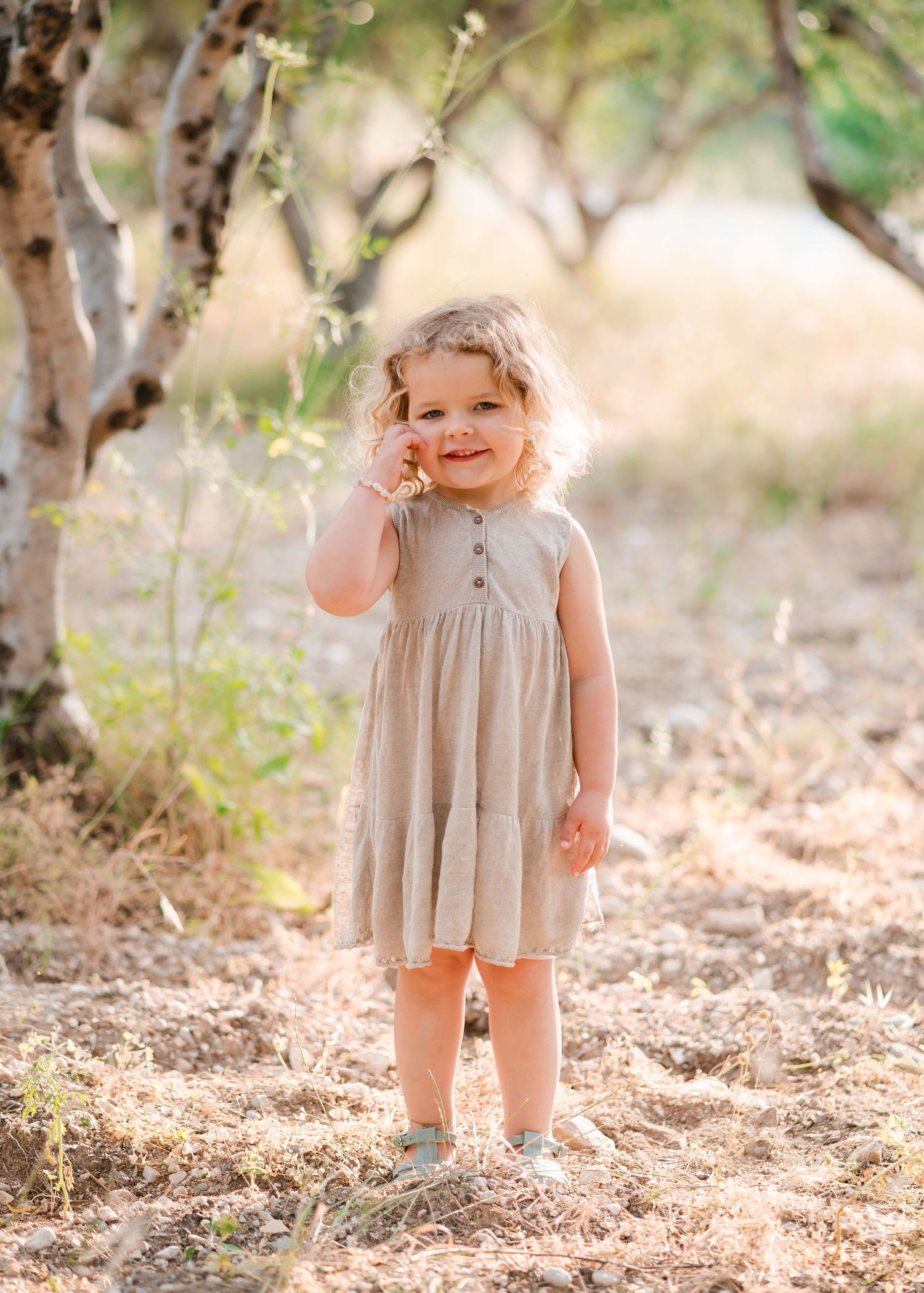 Young child in a flowy dress playing outdoors in golden sunlight. Fotograf Rhodos