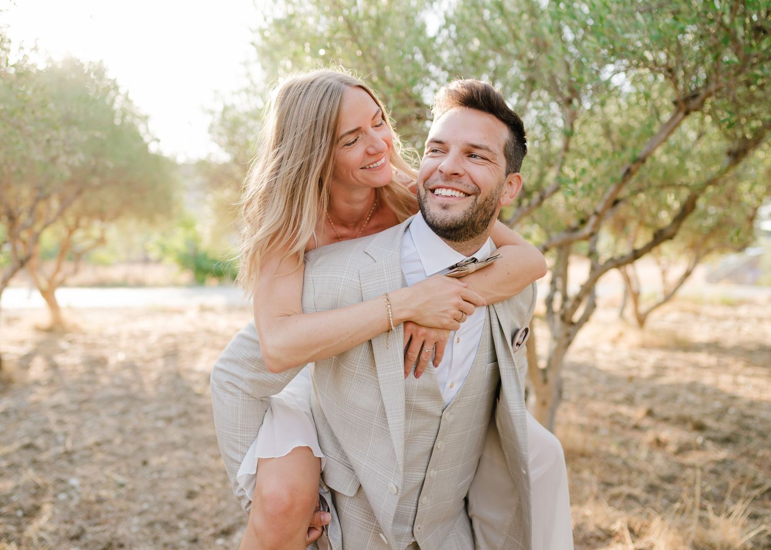 Verspieltes Brautpaar, das während eines Fotoshootings im Freien im Olivenhain lacht. Fotografin Rhodos - Hochzeitsfotograf Rhodos Tina Luci
