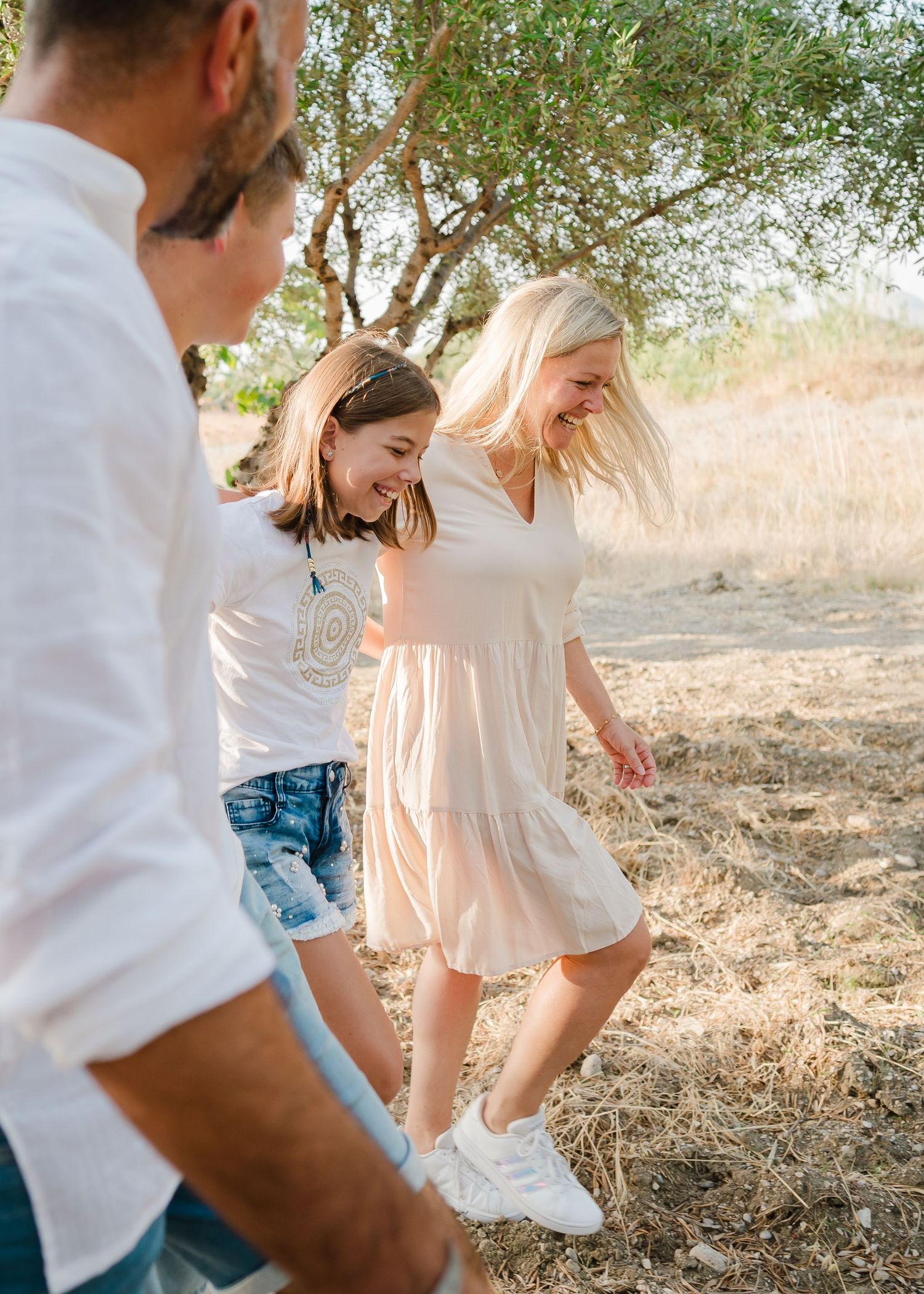 Candid moment of people walking through an olive grove in casual summer attire. Fotograf Rhodos