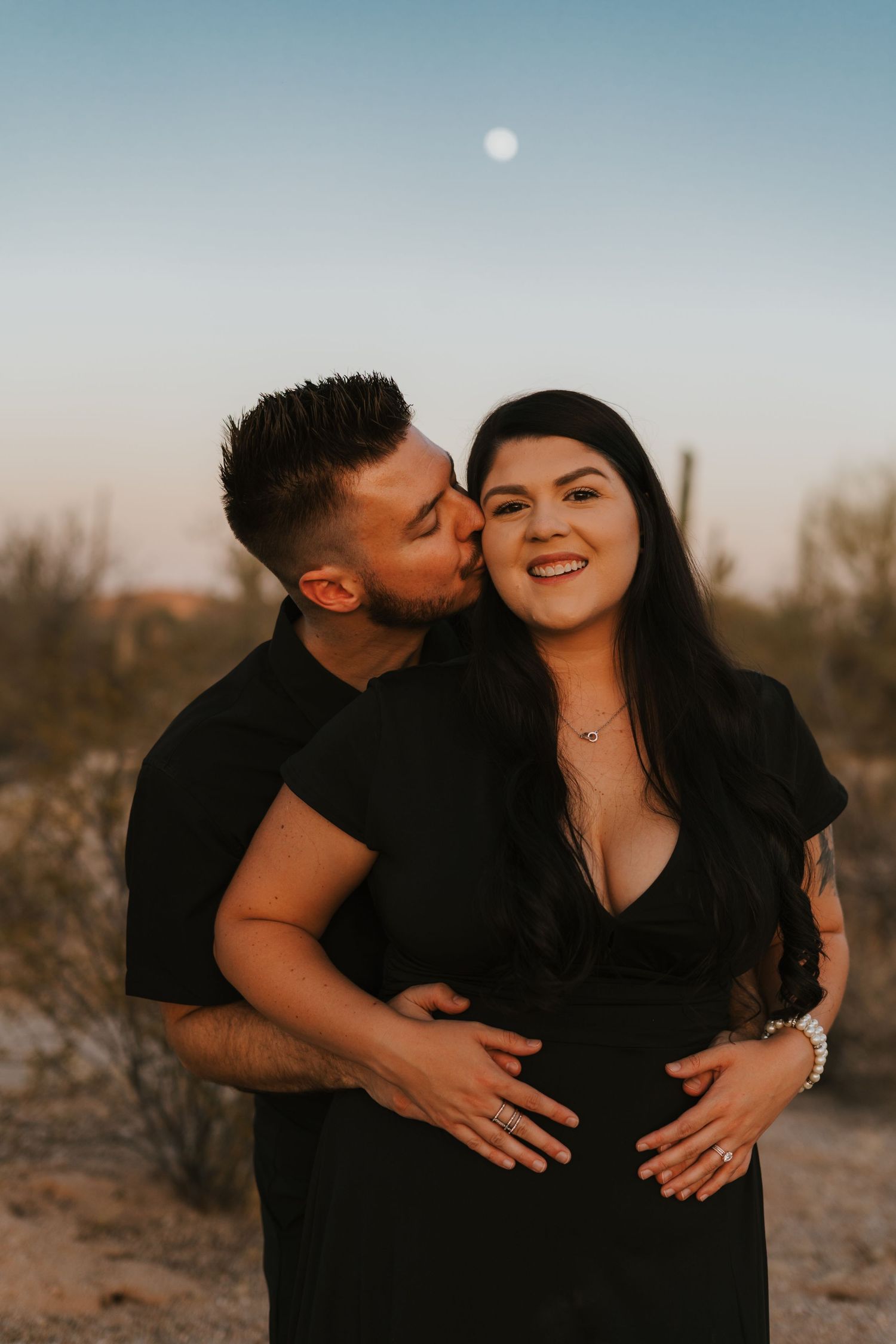 Couple embracing blue hour in the Arizona desert under a full moon. Captured with warmth and romantic tones.