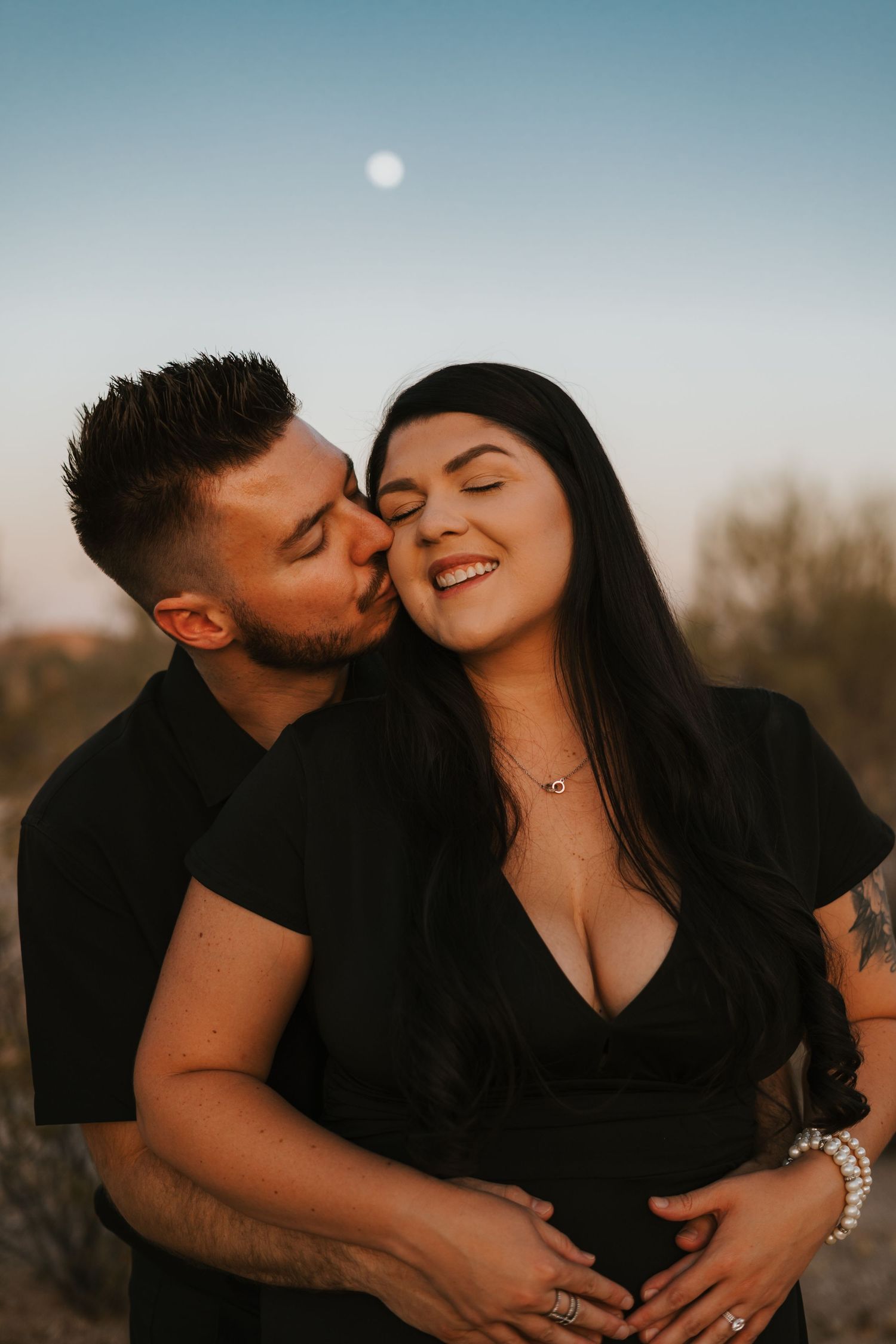 Couple embracing blue hour in the Arizona desert under a full moon. Captured with warmth and romantic tones.
