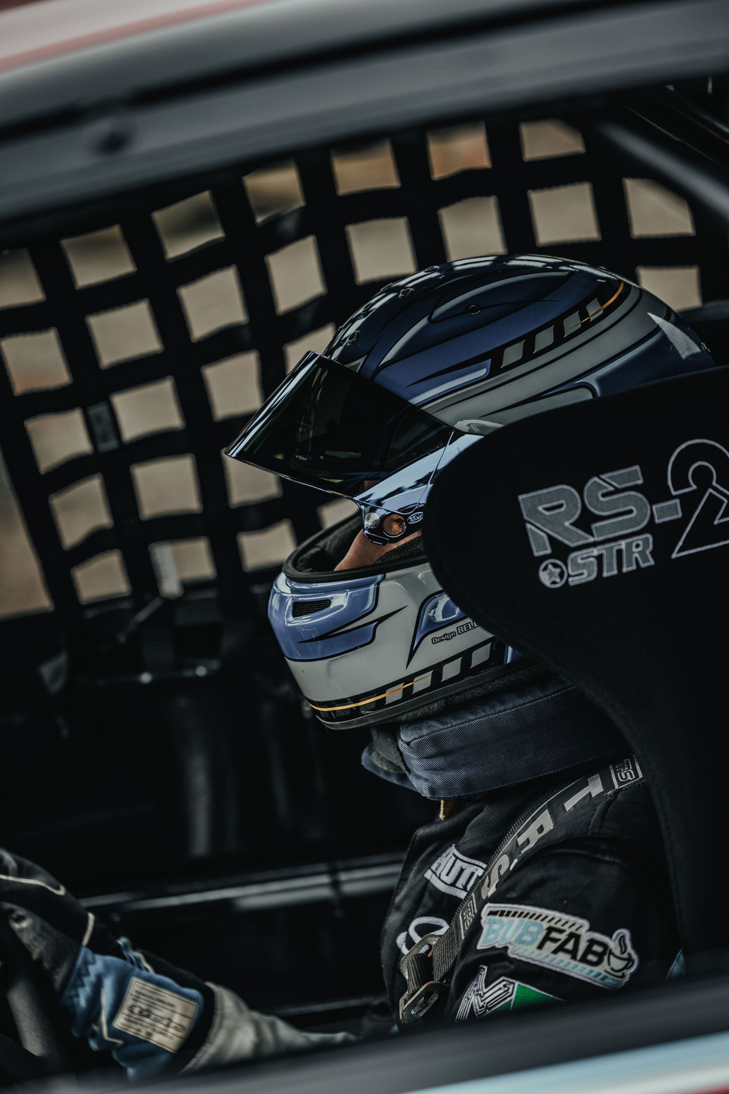 Professional racing helmet and safety equipment inside competition vehicle.