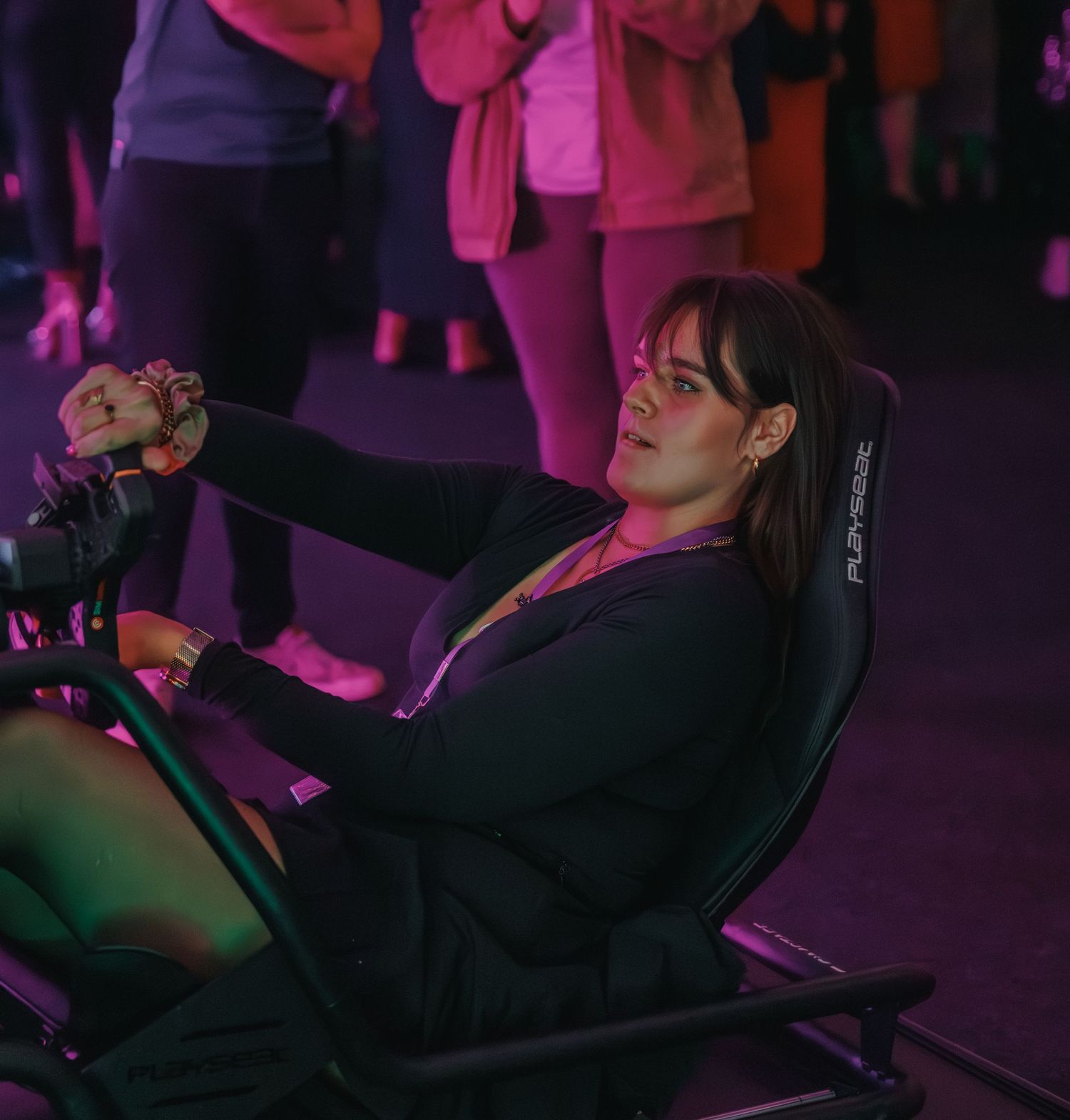 Person relaxing in gaming chair under purple ambient lighting.
