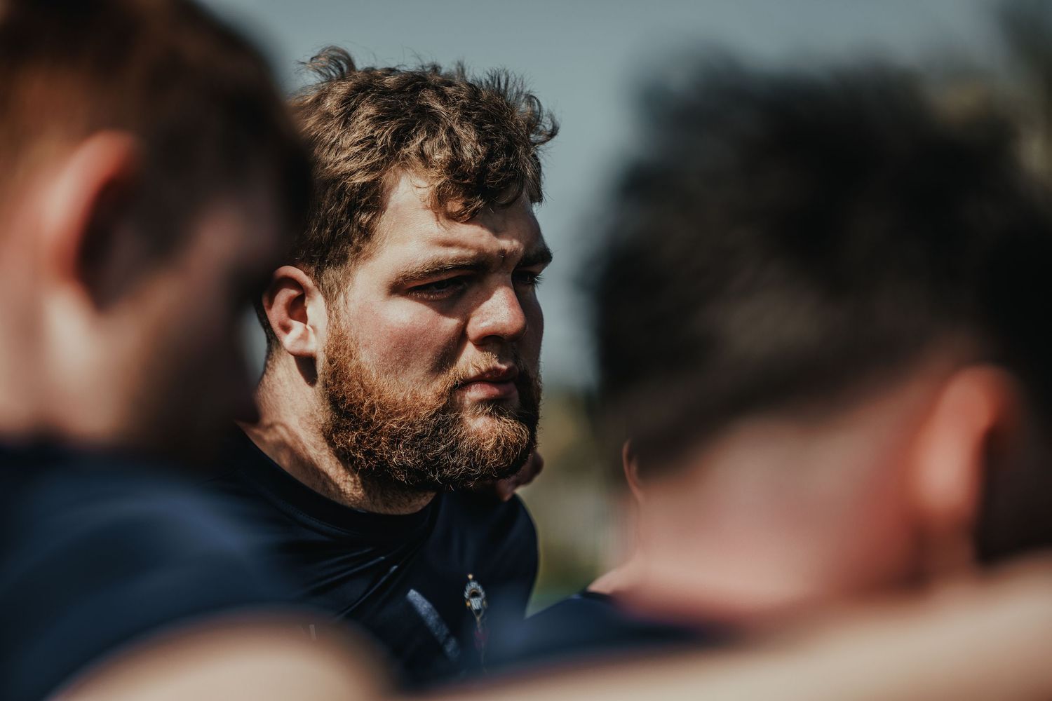 Rugby player in a navy uniform gazes intently during a match.