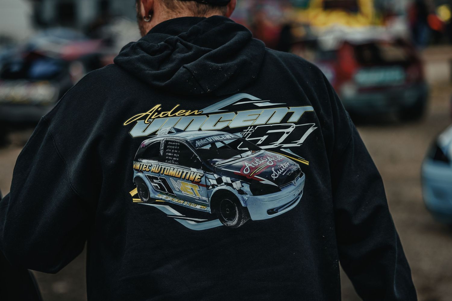 Racing-themed jacket showing custom car design artwork on black fabric.