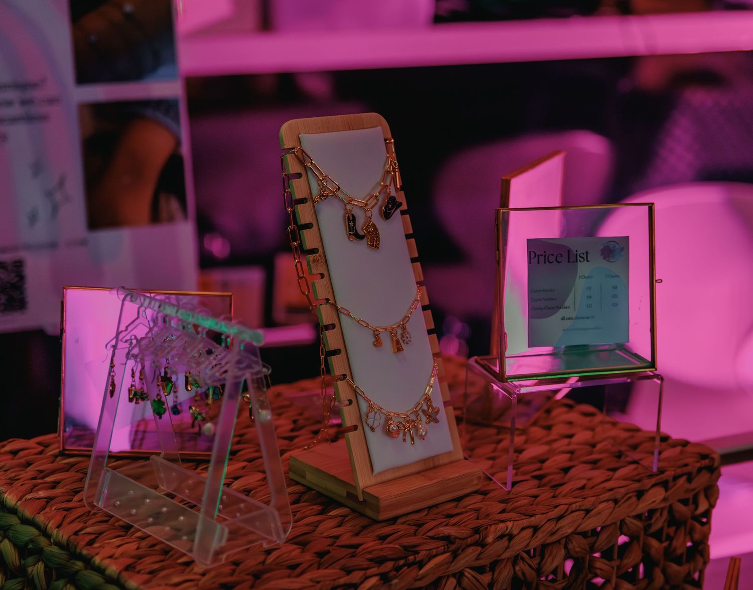 Jewelry display stand with necklaces illuminated by pink ambient lighting.