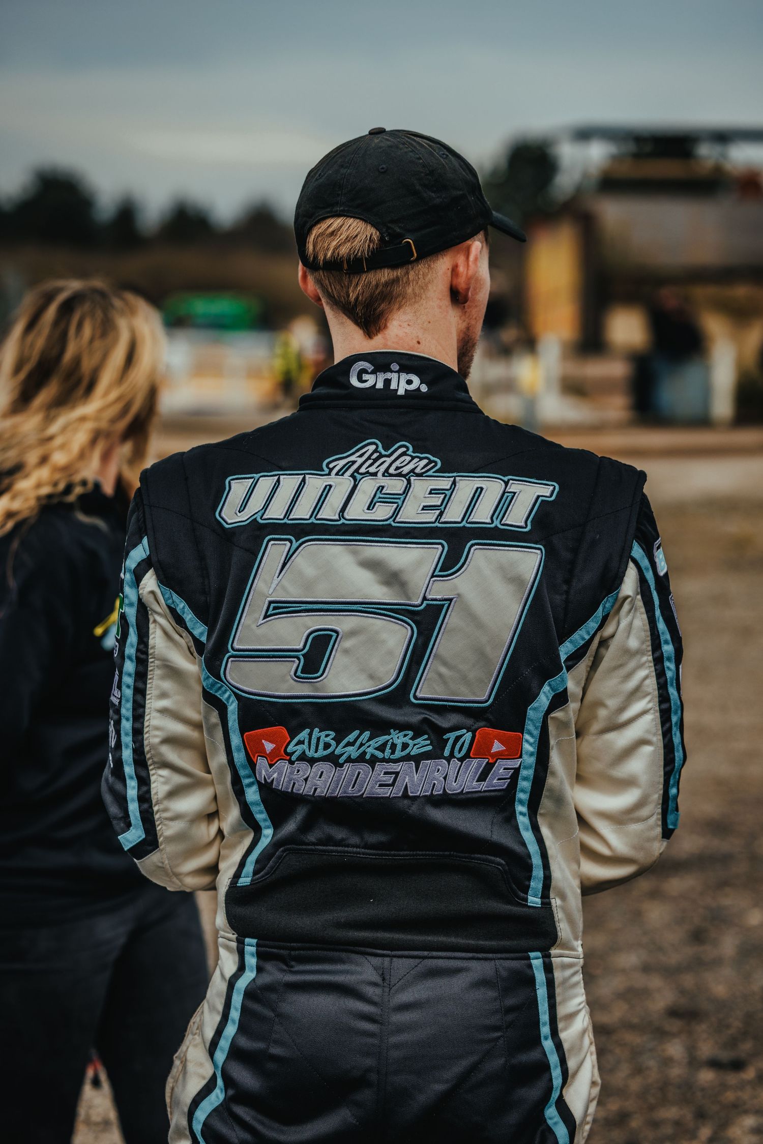 Back view of racing suit showing number 51 and Vincent branding in teal and white.