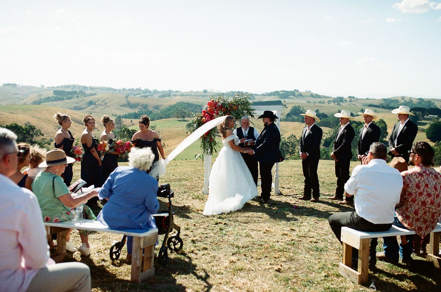 A collection of panoramic outdoor wedding ceremony photos showing people gathered on a hillside overlooking a scenic landscape.