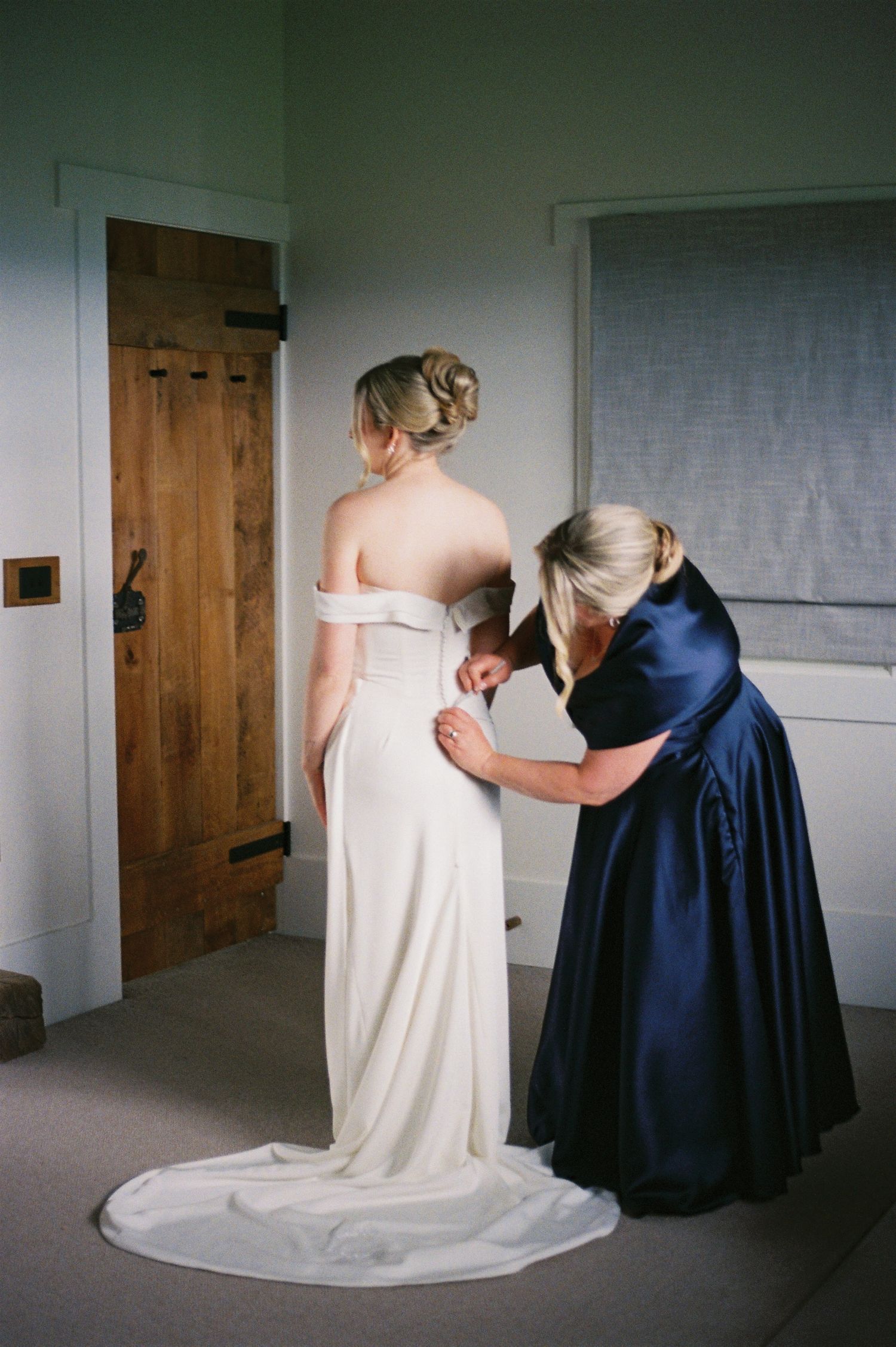 A sequence of images showing two figures in white and navy blue garments interacting in a minimalist interior space.