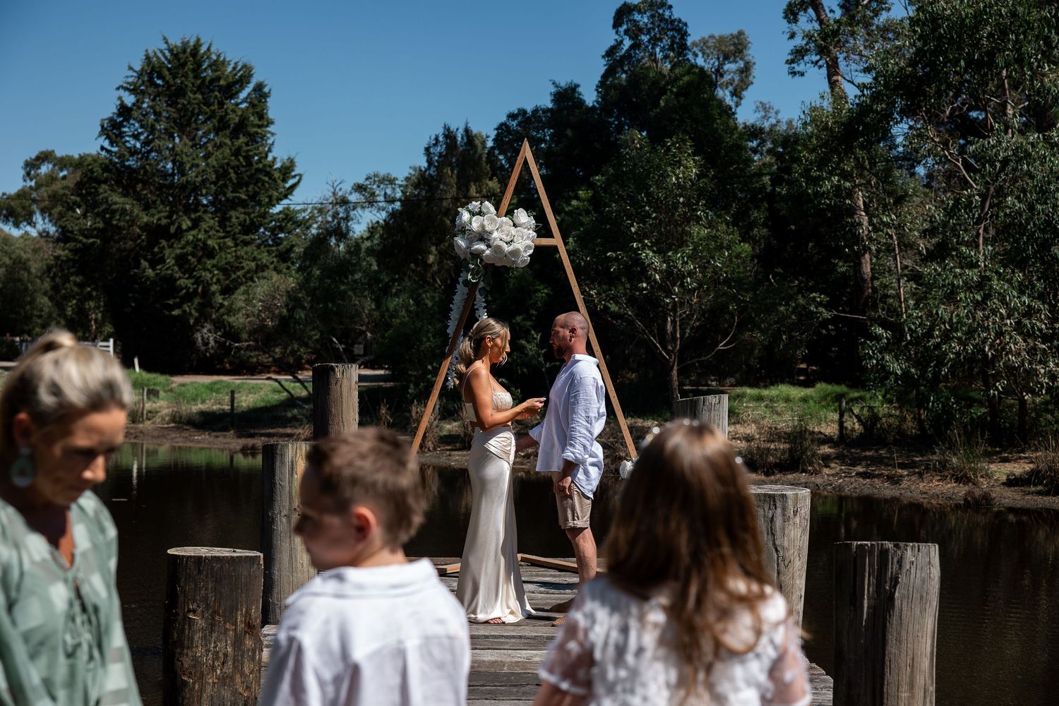 A montage of people celebrating and having fun at an outdoor wedding reception by a lake on a sunny summer day.