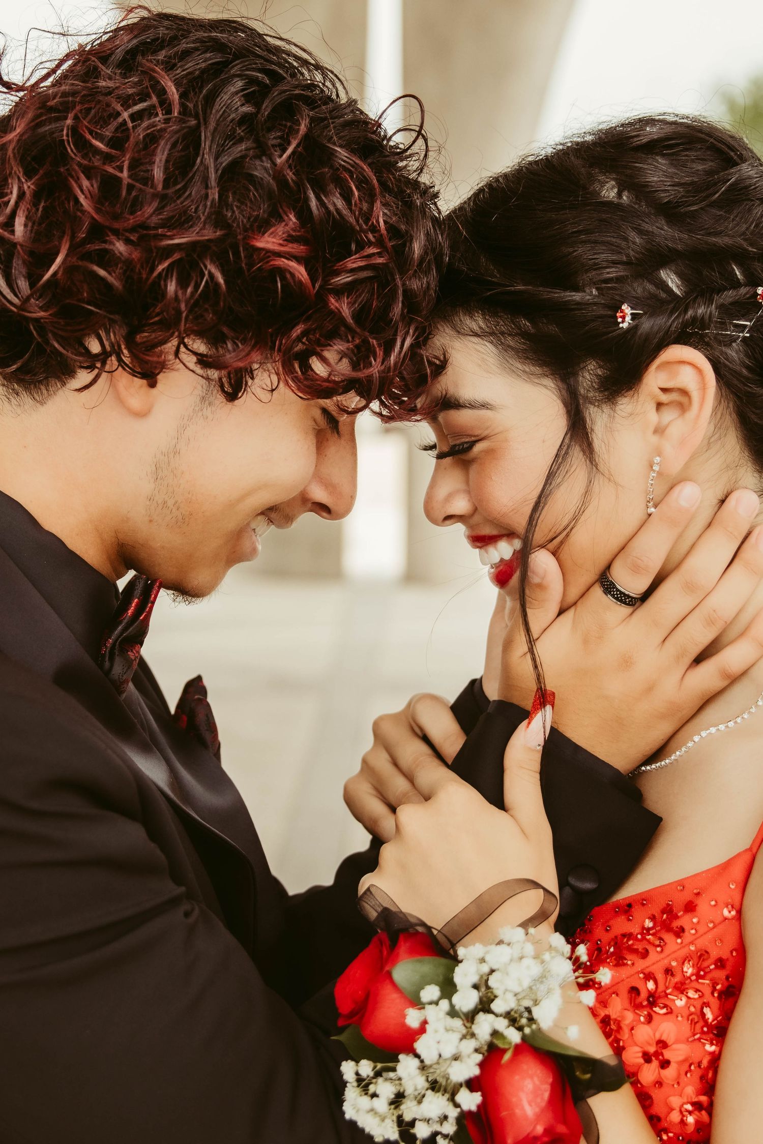 A tender moment between a couple in formal wear with baby's breath corsage before prom in San Antonio, Texas