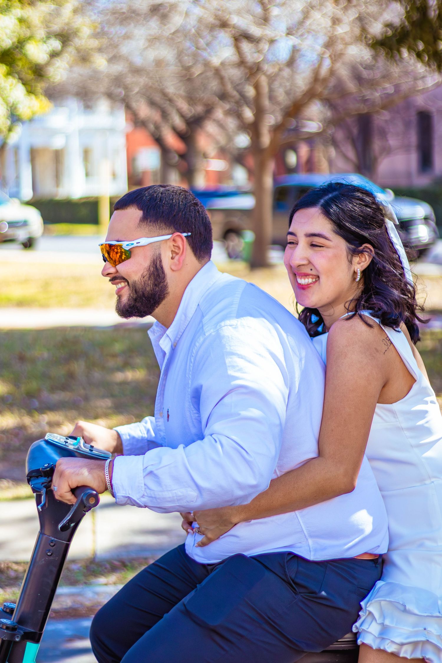Couple shares lighthearted moment while riding electric scooter together in downtown San Antonio, Texas.