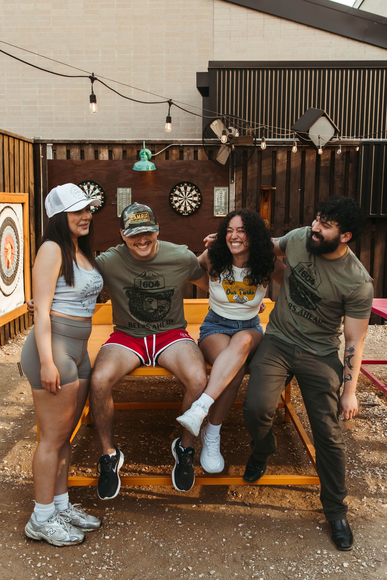 A group of bartenders at Camp 1604 in San Antonio, Texas advertising their spring 2025 merch