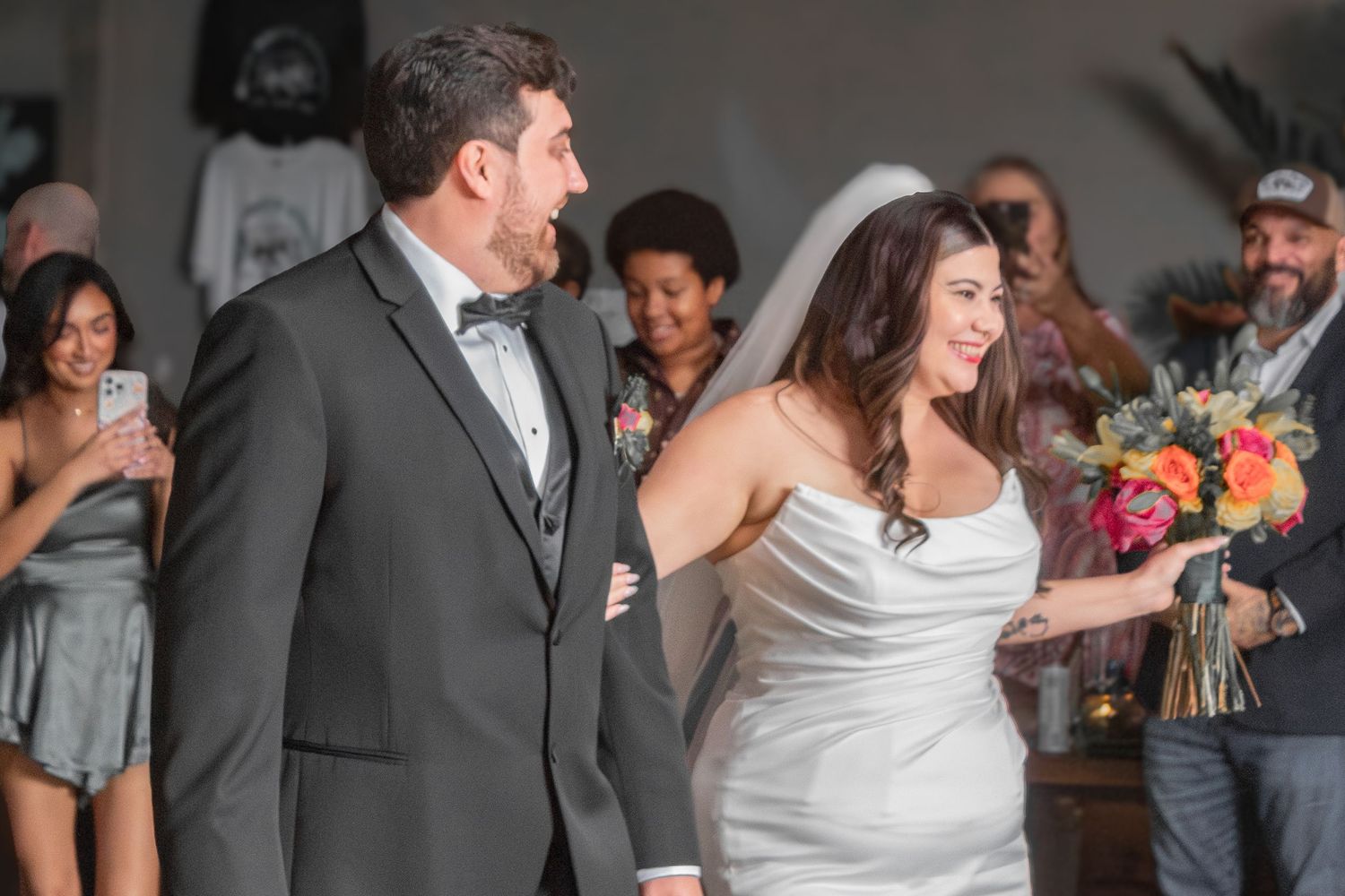 A joyous wedding celebration moment with guests looking on as the newlyweds express their happiness.