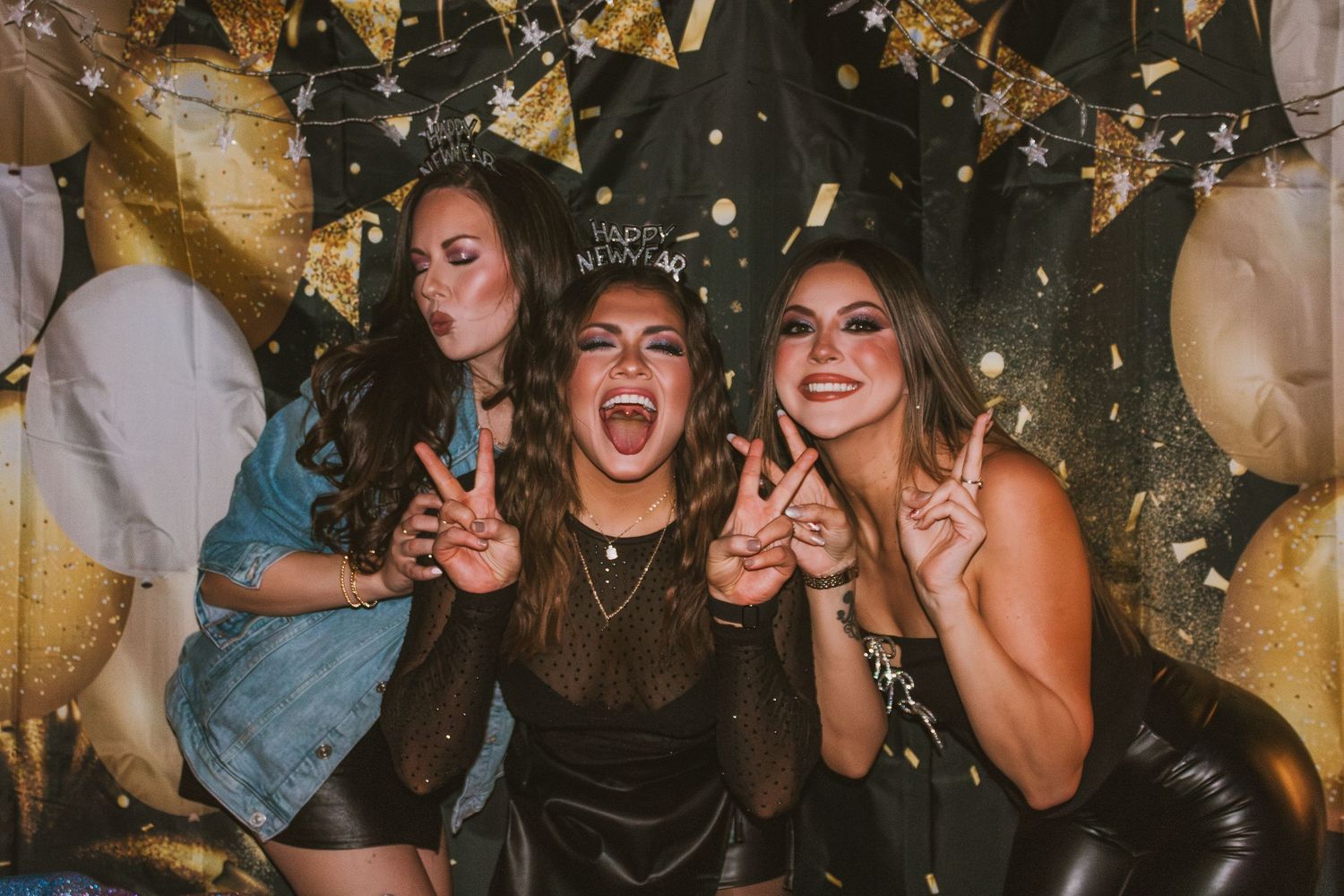 Friends celebrating at a party with confetti and balloons in a dimly lit venue.