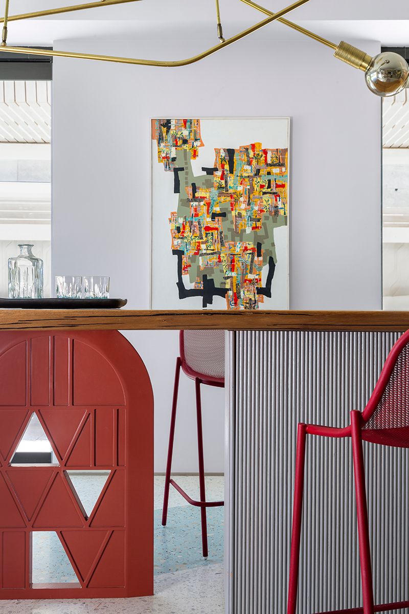 Modern interior design featuring red geometric door panels and contemporary bar seating with abstract wall art.