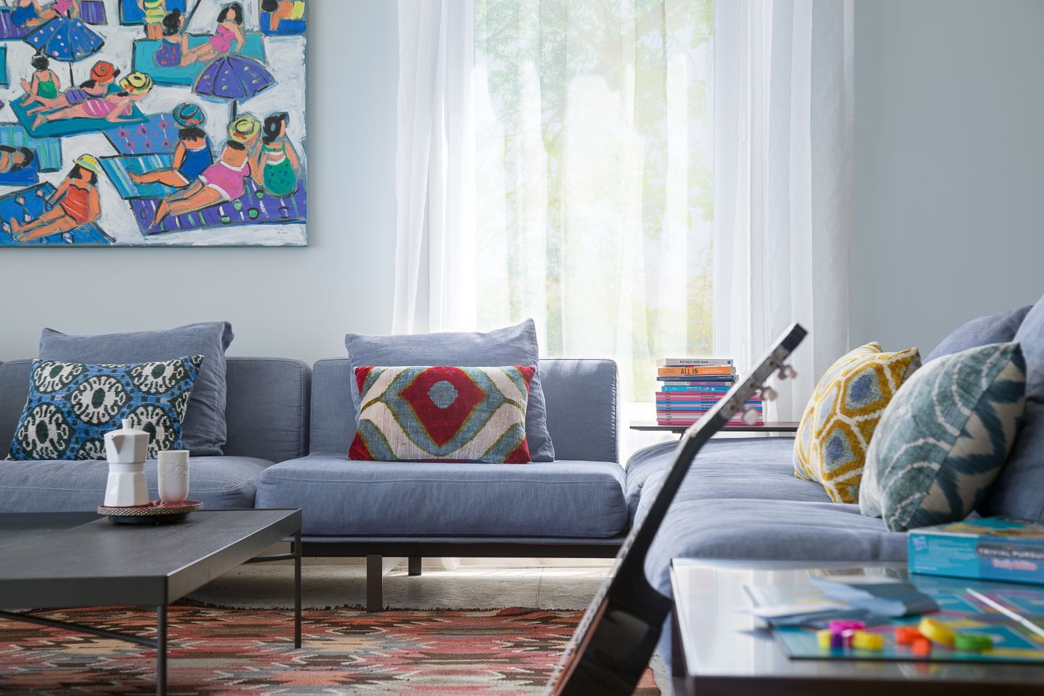 Cozy living room corner with gray sectional sofa and vibrant wall art.