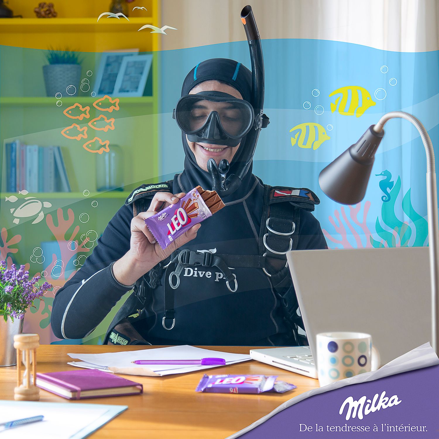 Scuba diver in full gear holding Milka chocolate bar at desk with underwater-themed background.
