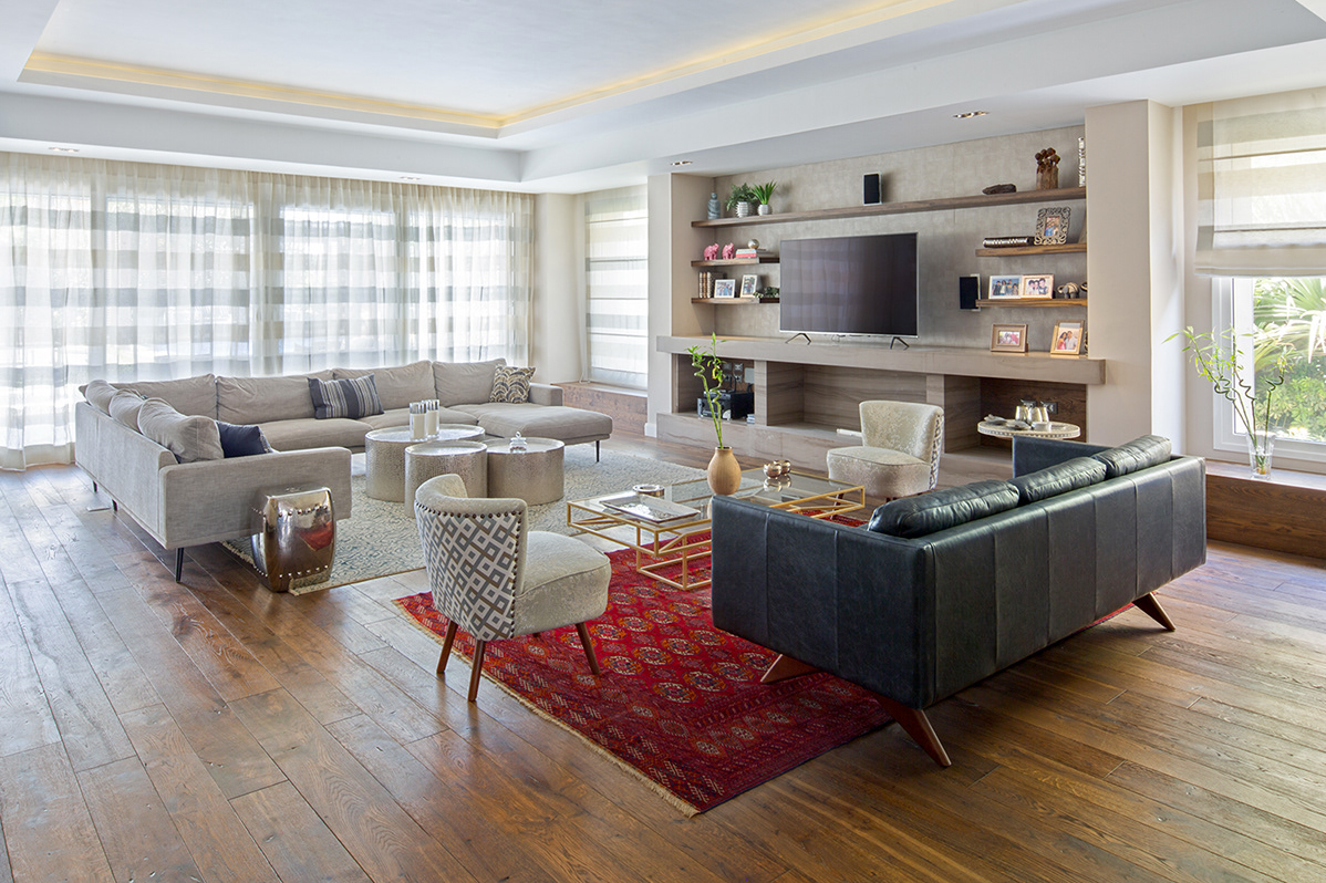 Contemporary living room with grey sectionals, red area rug, and built-in entertainment center.