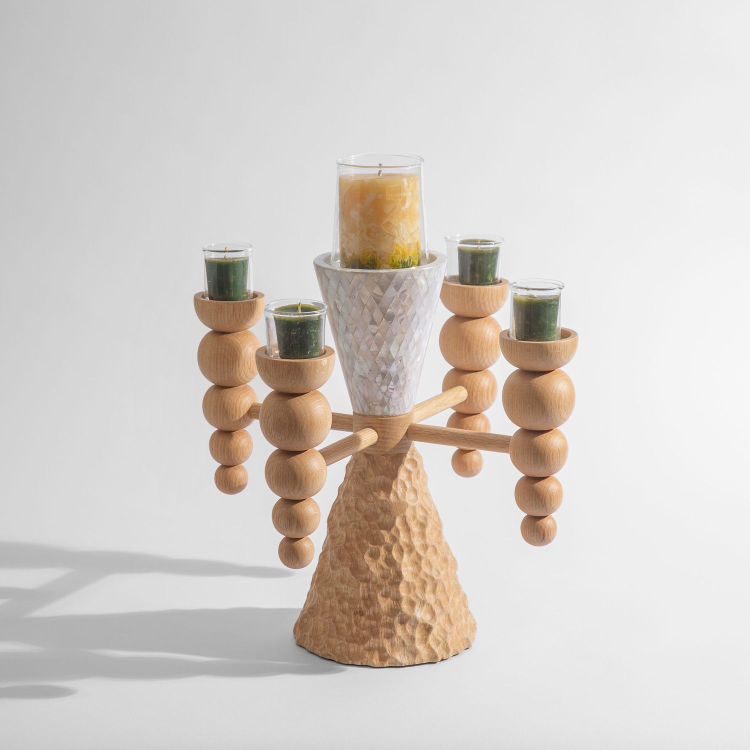 Unique spiral wooden candelabra with textured base and spiral arms holding green and white candles.