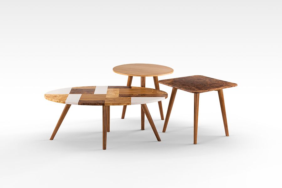 Set of three modern wooden coffee tables with varying heights and designs.