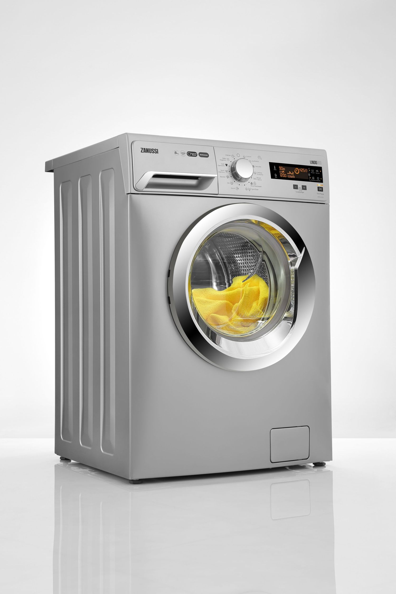 Silver front-loading washing machine with yellow fabric visible through the glass door.