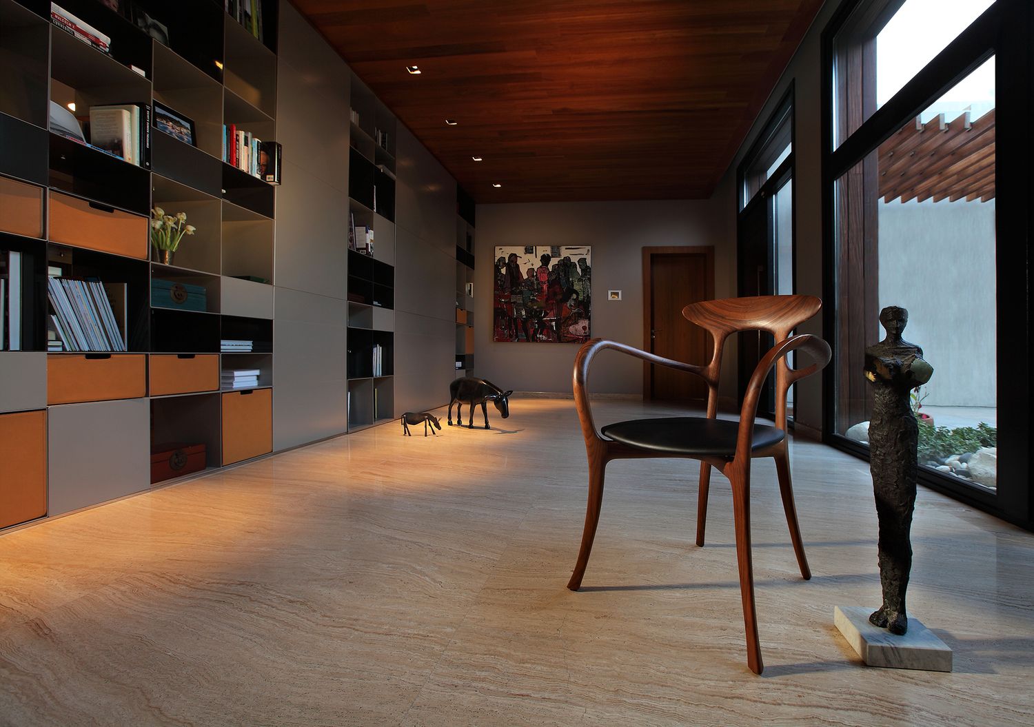 Modern hallway with wooden floors, built-in shelving and artistic decor.
